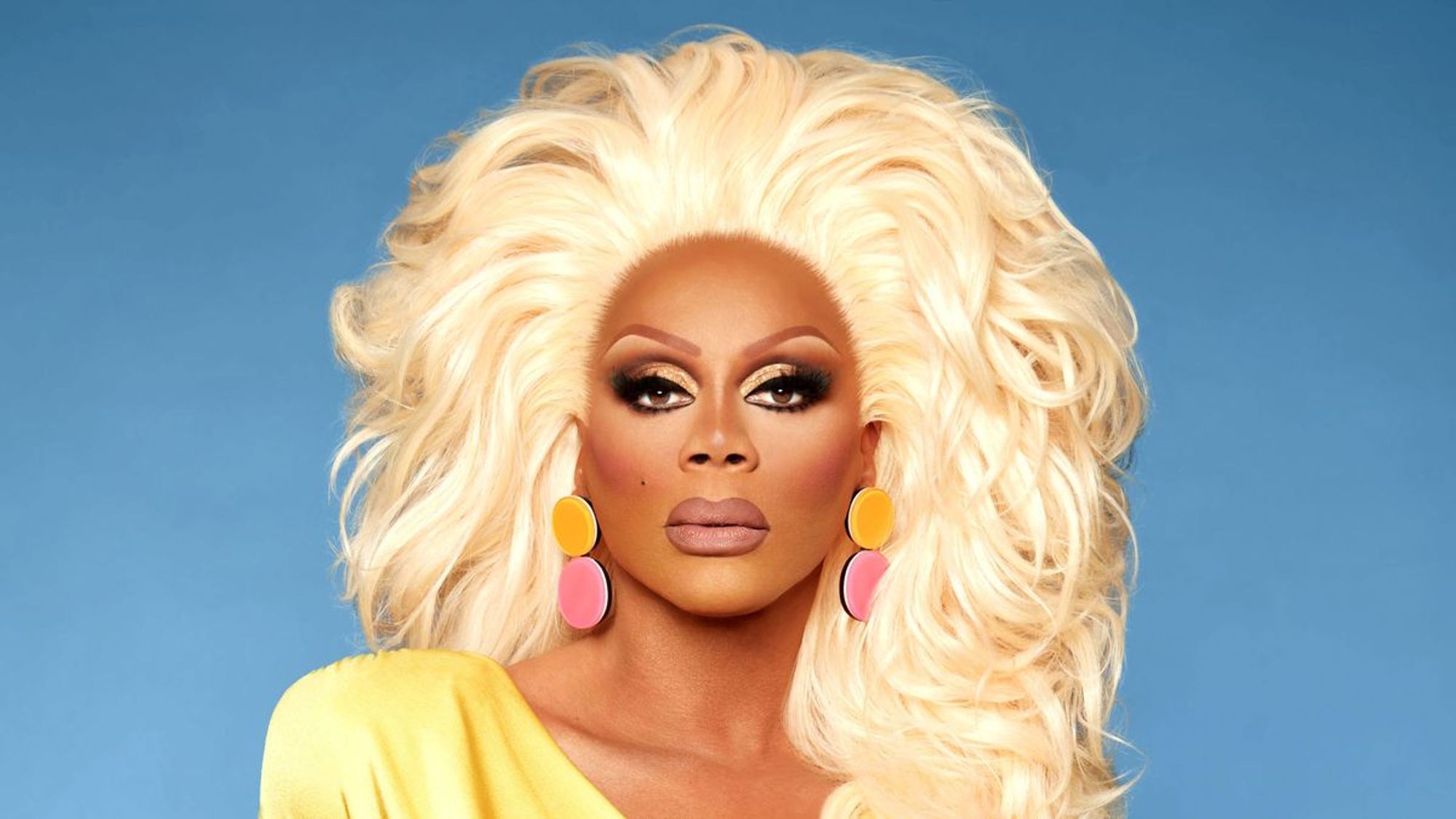 Rupaul, famous drag queen, mugs on a teal background.