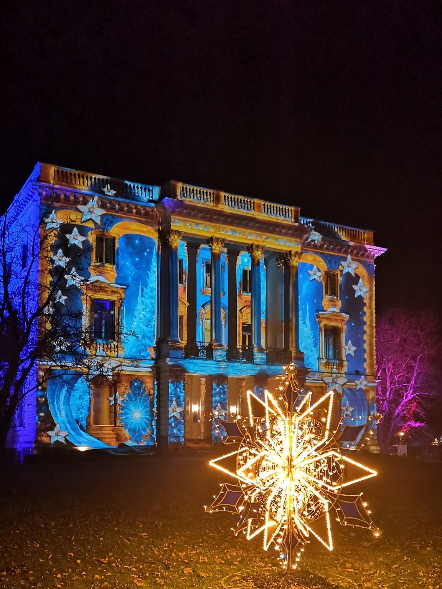 Blue illuminated little palace with shiny star in the foreground.