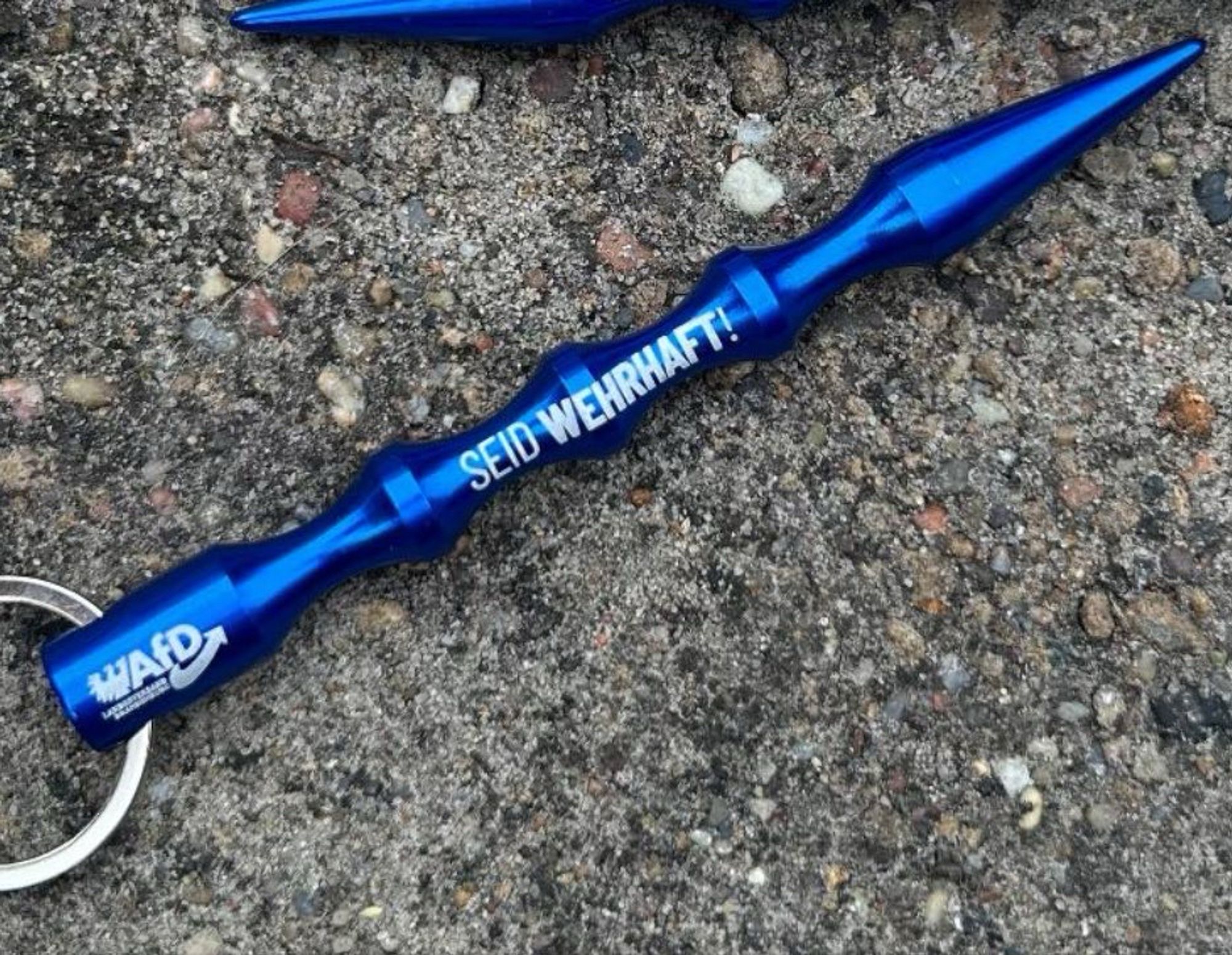 Ein blaues Kubotan  aus Aluminum mit der Aufschrift „AfD Brandenburg“ und „Seid Wehrhaft!“