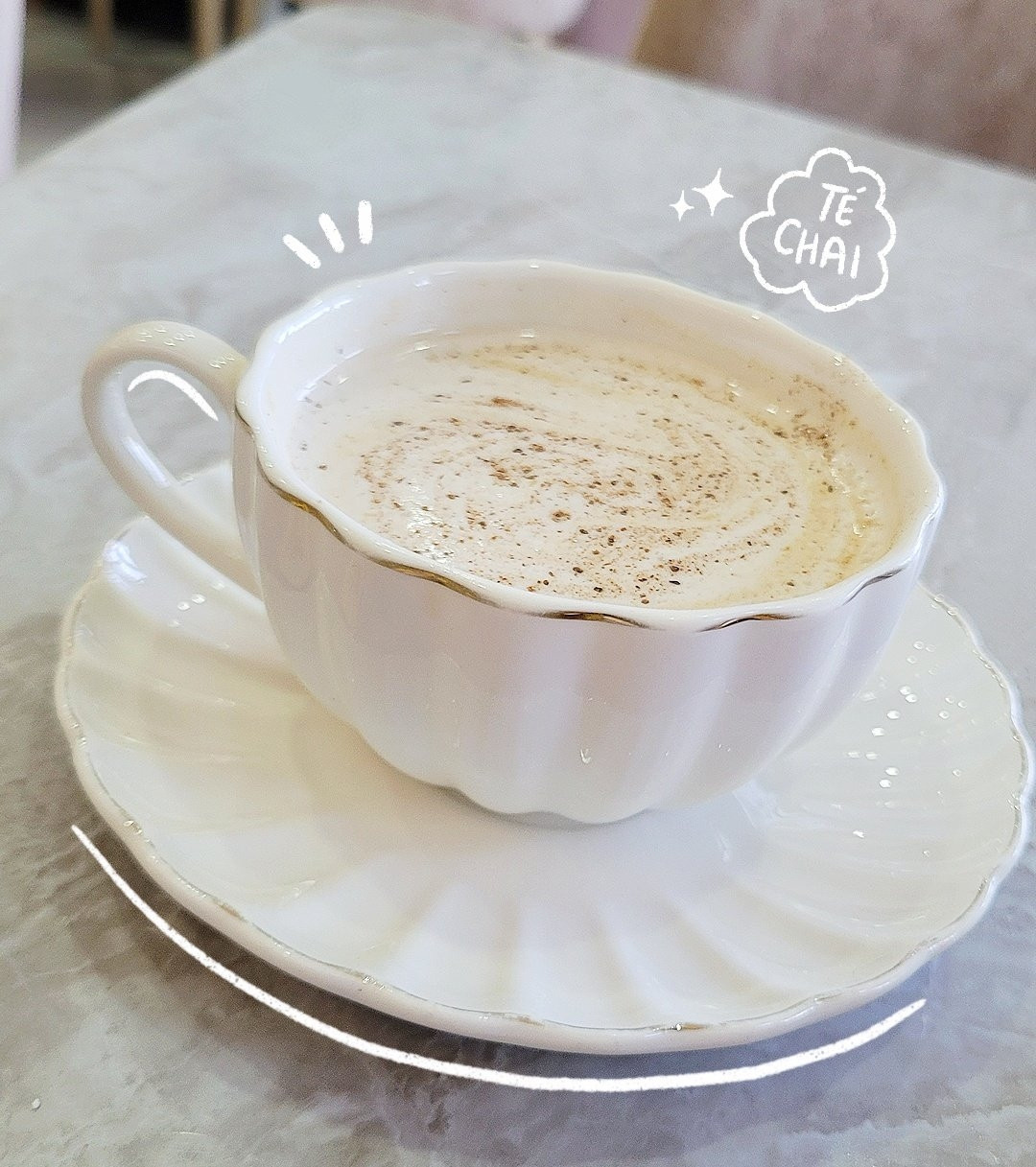 A white cute cup of chai tea on a grey marmol table