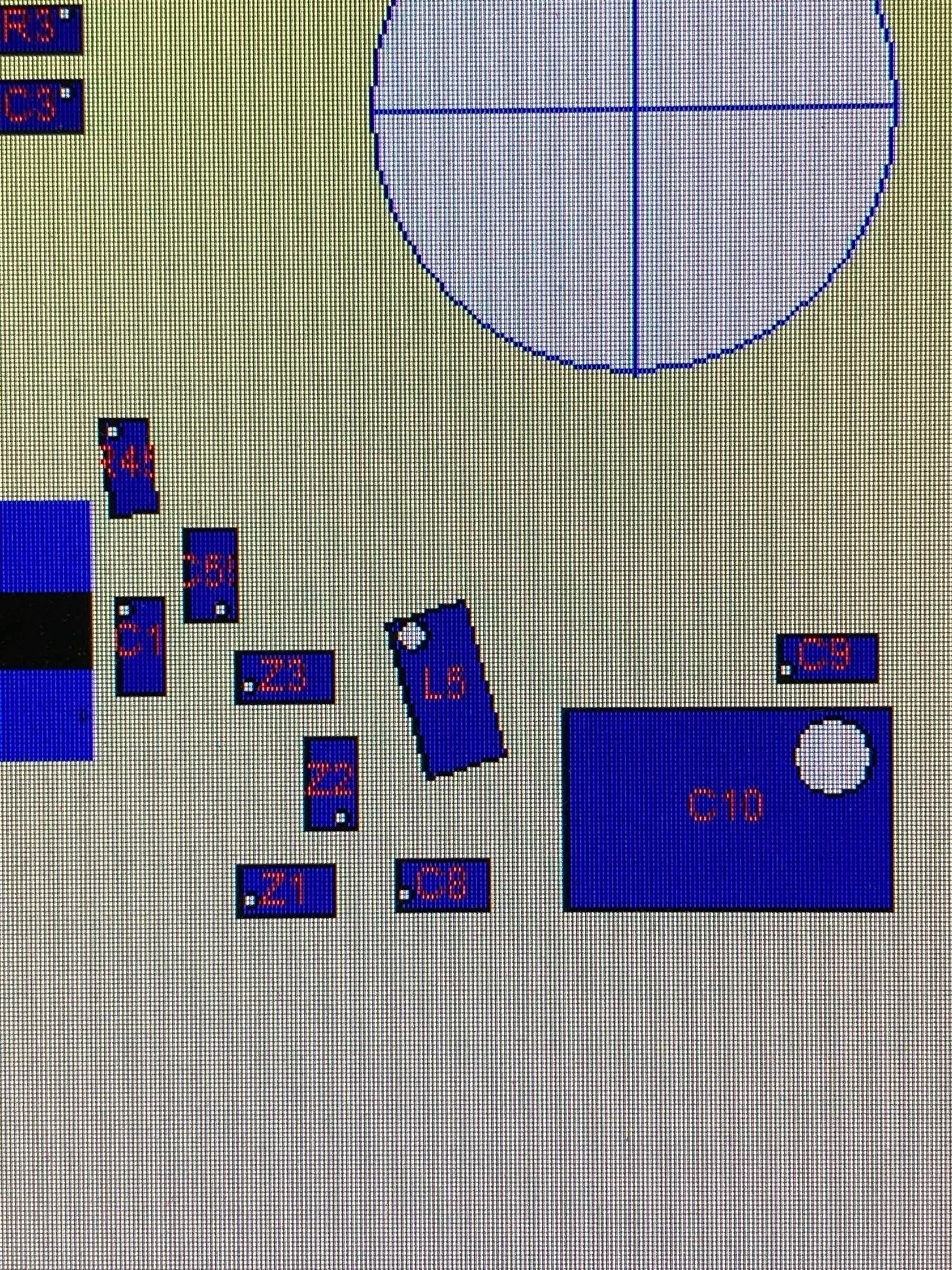 A photo of a monitor showing a layout of a pcb board.  A few components are skewed 5-15degrees off from straight vertical or horizontal angles.