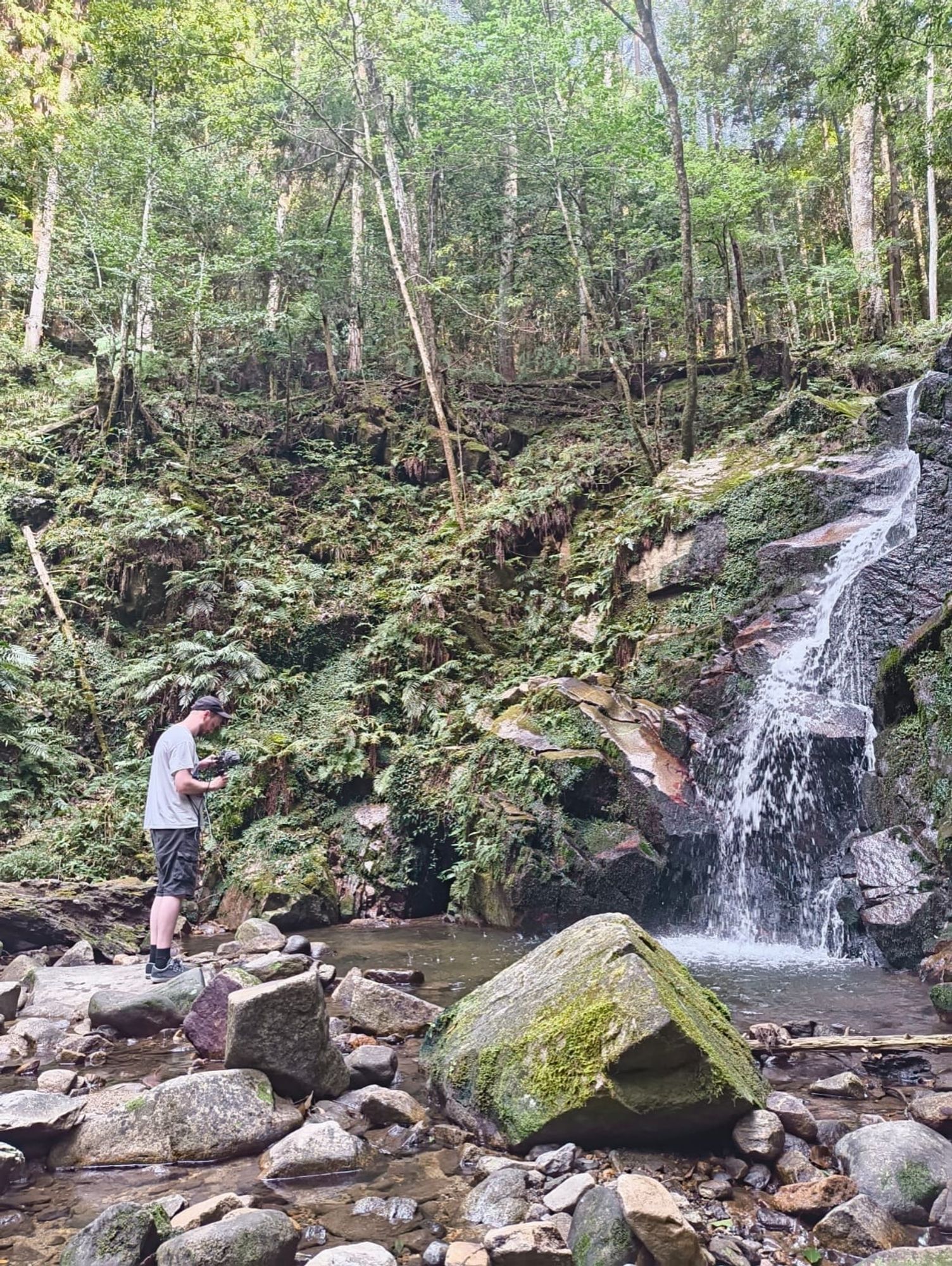 A sound designer in the left, recording a waterfall on the right