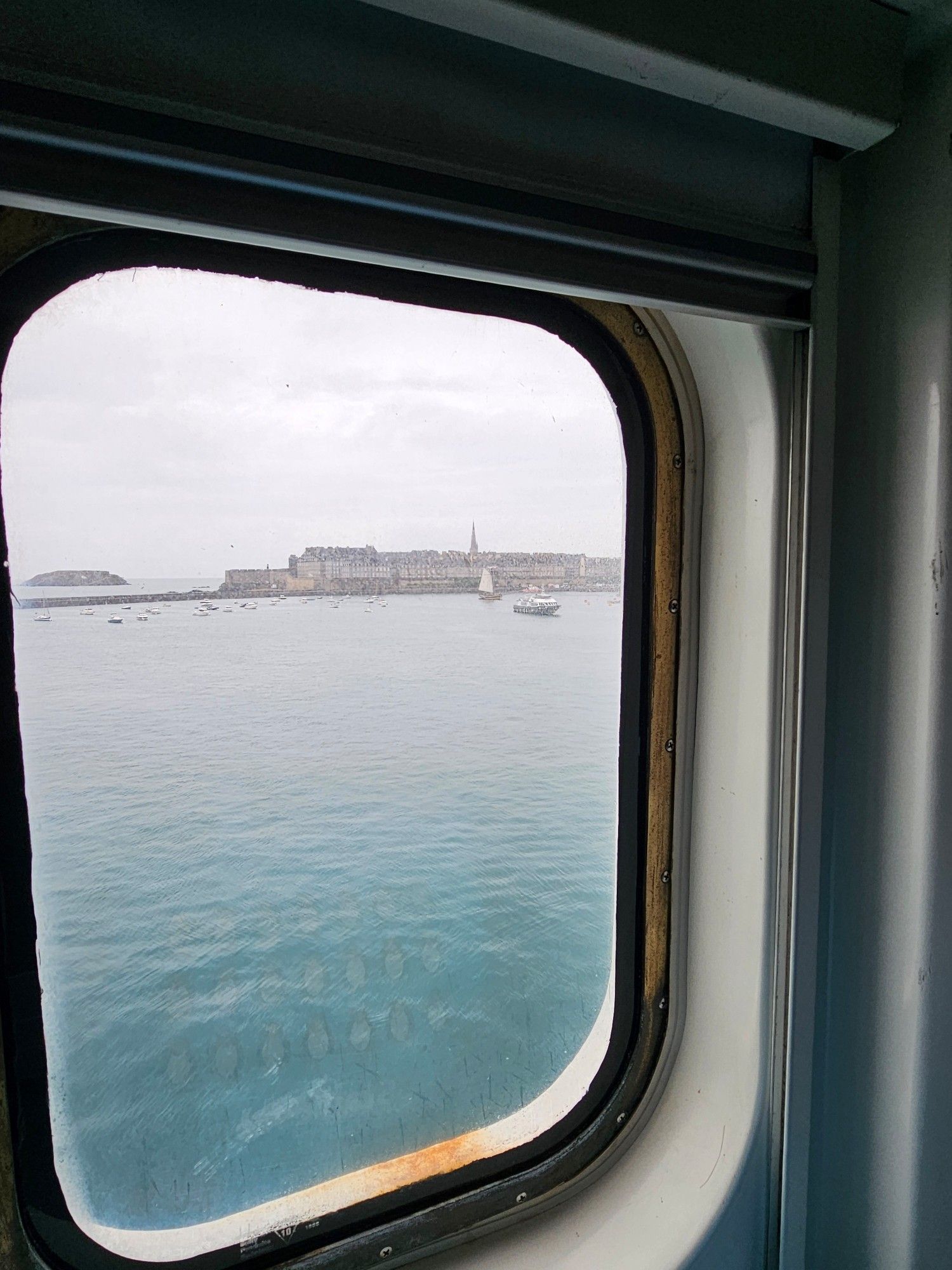 View of a rainy St. Malo from a cabin porthole