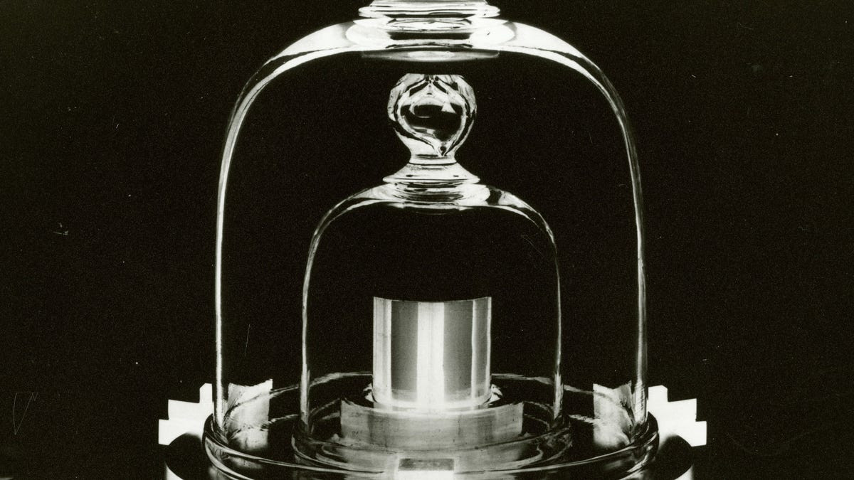 The Standard Kilogram, a silver metal weight inside of a pair of glass chambers.