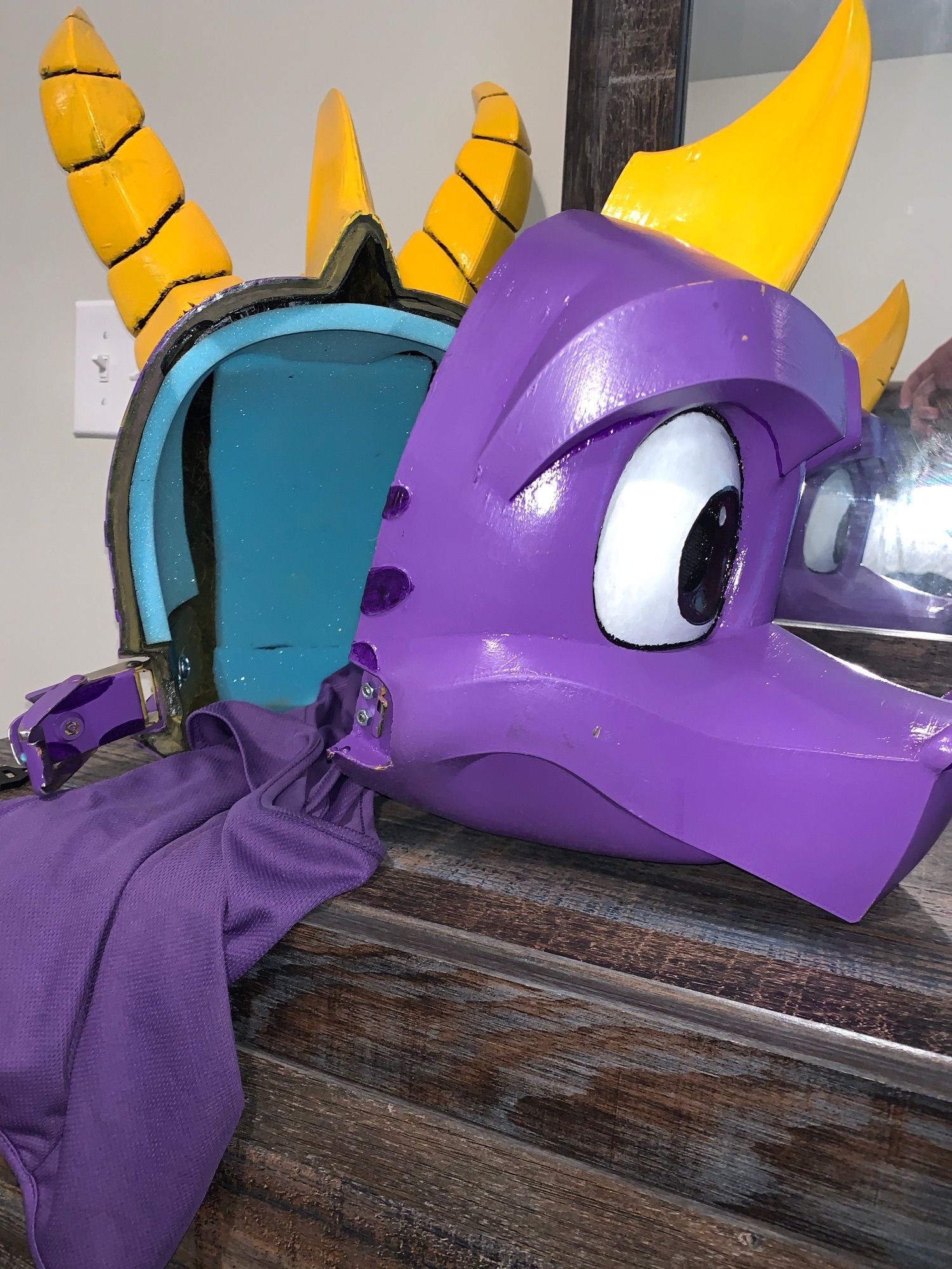 (Front angle view) 

An open view of my recently obtained two-piece Spyro the Dragon mask. Both halves can be locked together via bolted latches with the special key pictured to render the mask irremovable, though locking isn’t necessary to keep the mask on. My purple balaclava lies between the open halves.