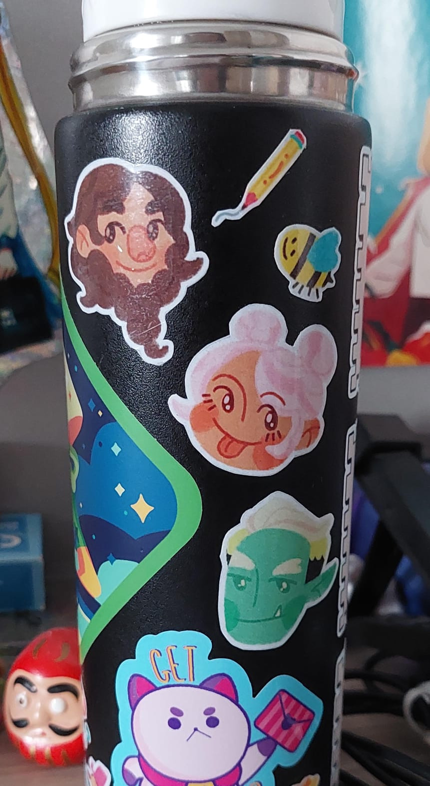 Black water bottle with stickers of the drawings of Grendan, Rosé and York