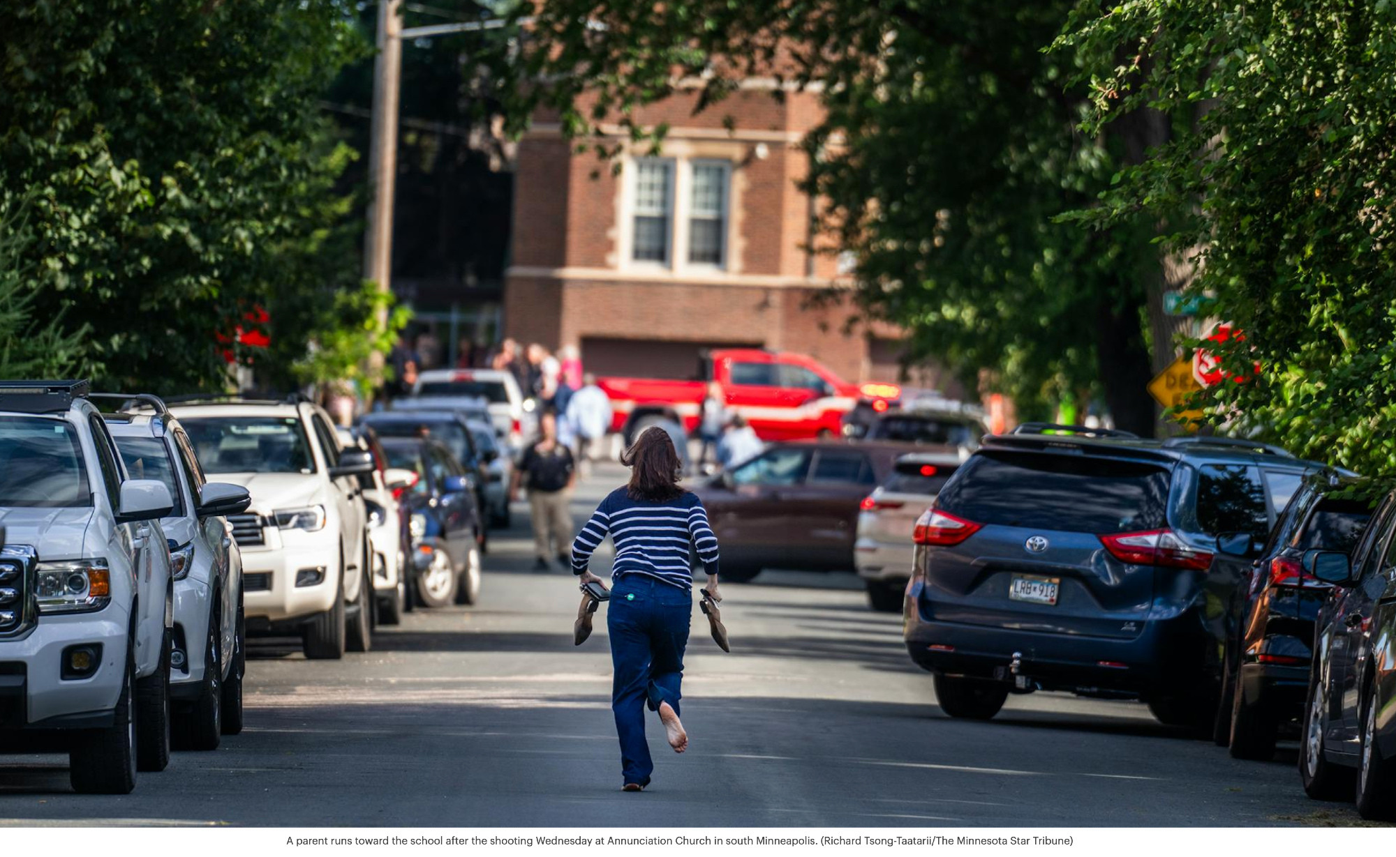 A parent runs toward the school after the shooting Wednesday at Annunciation Church in south Minneapolis. (Richard Tsong-Taatarii/The Minnesota Star Tribune)