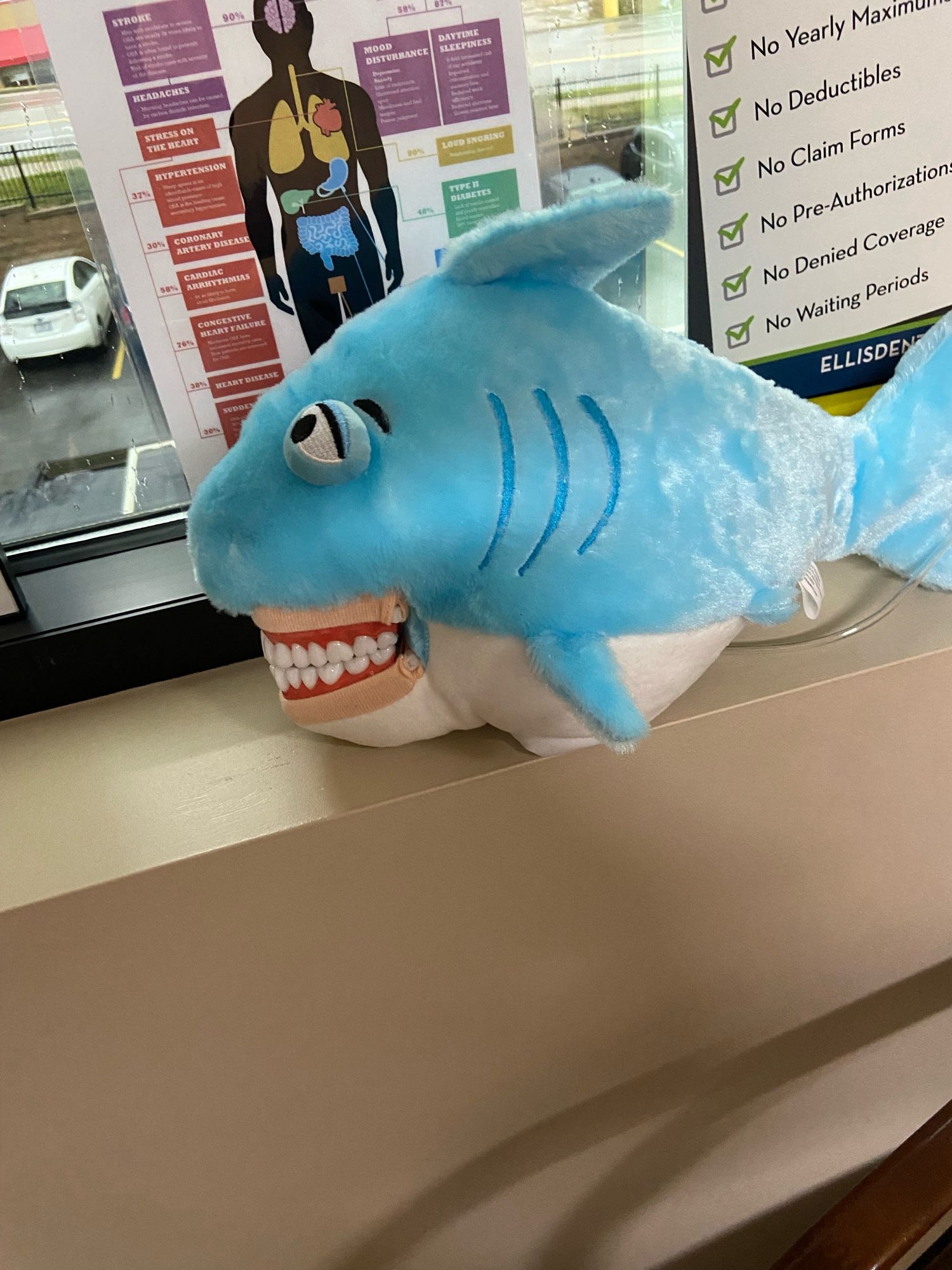 A shark puppet with human eyes and teeth