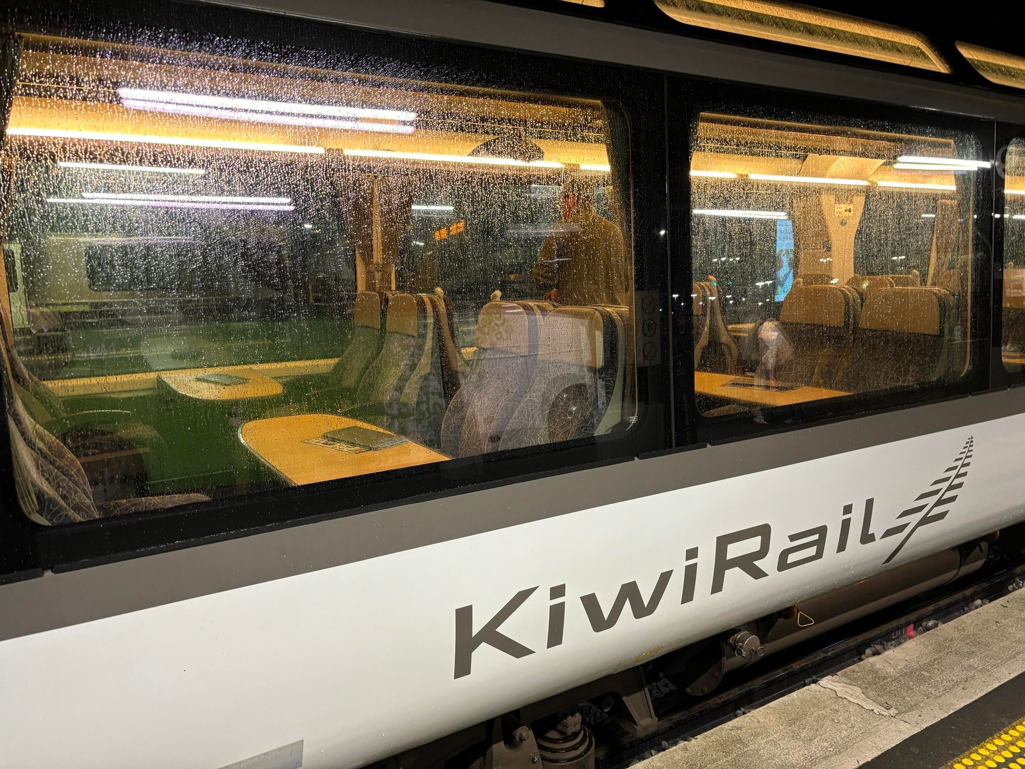 Exterior of Northern Explorer train, looking in past rain-flecked windows.