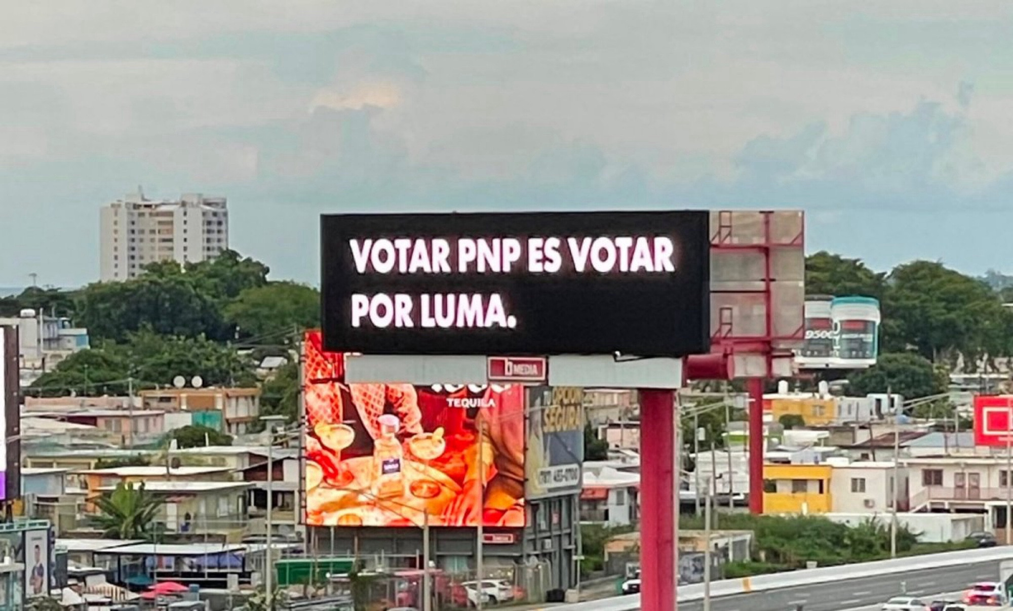 Outdoor na cidade de Porto Rico com o fundo preto e o texto branco em tradução livre “votar pelo pnp é votar pela luma”. Empresa privada responsável pela distribuição de energia elétrica (ou pela falta dela) em Porto Rico