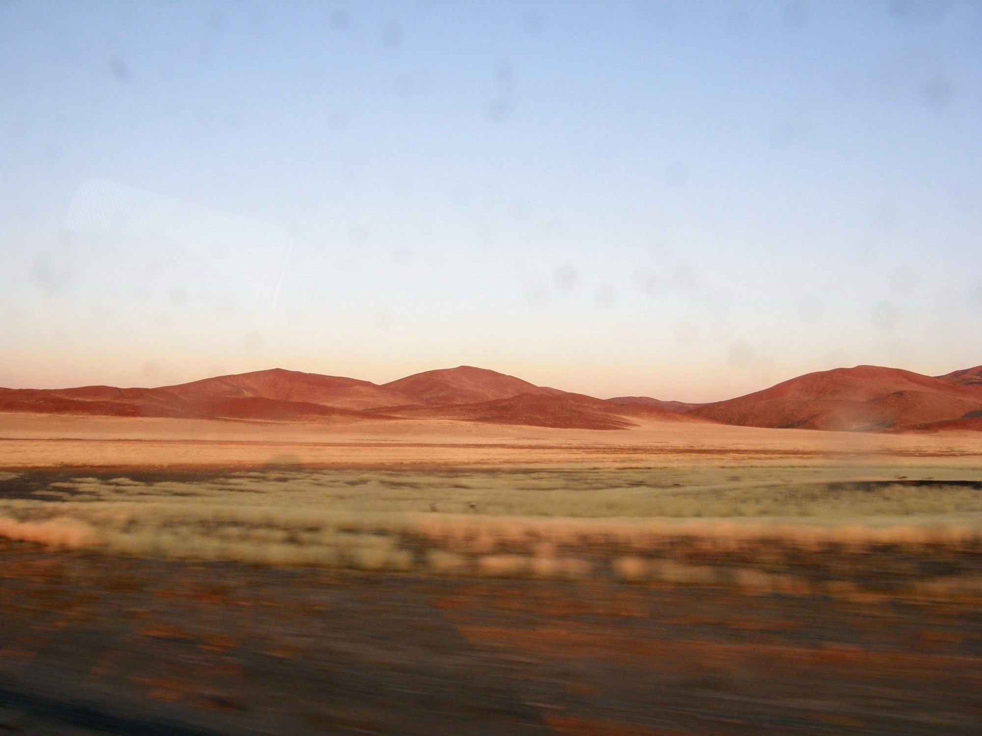 Op weg in de Namib. Heel vroeg -want anders wordt het te heet- zie je de eindeloze duinen met nog veel schaduw.