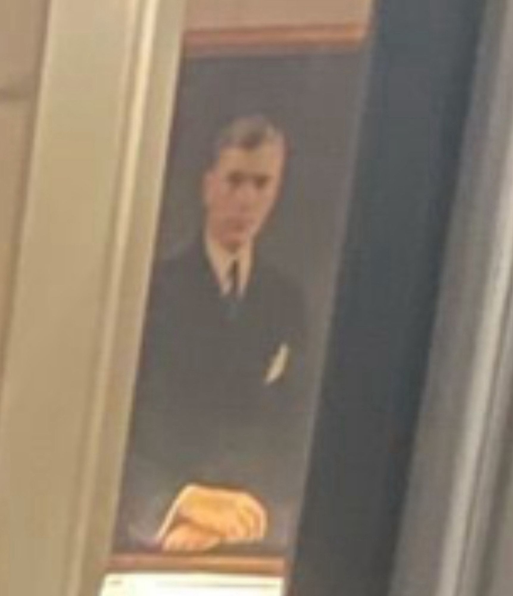 Photo of an oil portrait in someone’s foyer. The subject looks like a minister, or a school administrator or something.