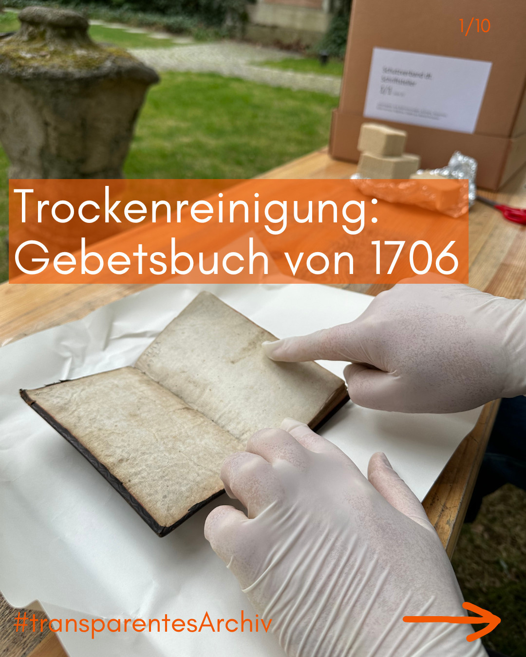 Behandschuhte Hände zeigen auf mit Schimmel befallenes Gebetsbuch von 1706, das trockengereinigt werden soll. Es liegt auf einem Tisch im Garten der Monacensia, darauf auch Karton und Latexschwämme. Beispiel für #transparentesArchiv