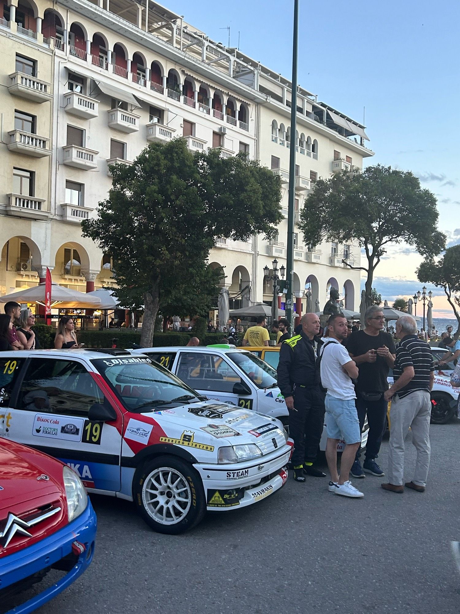 A Peugeot 106 phase 1 rally car and a crowd in front of the cars!