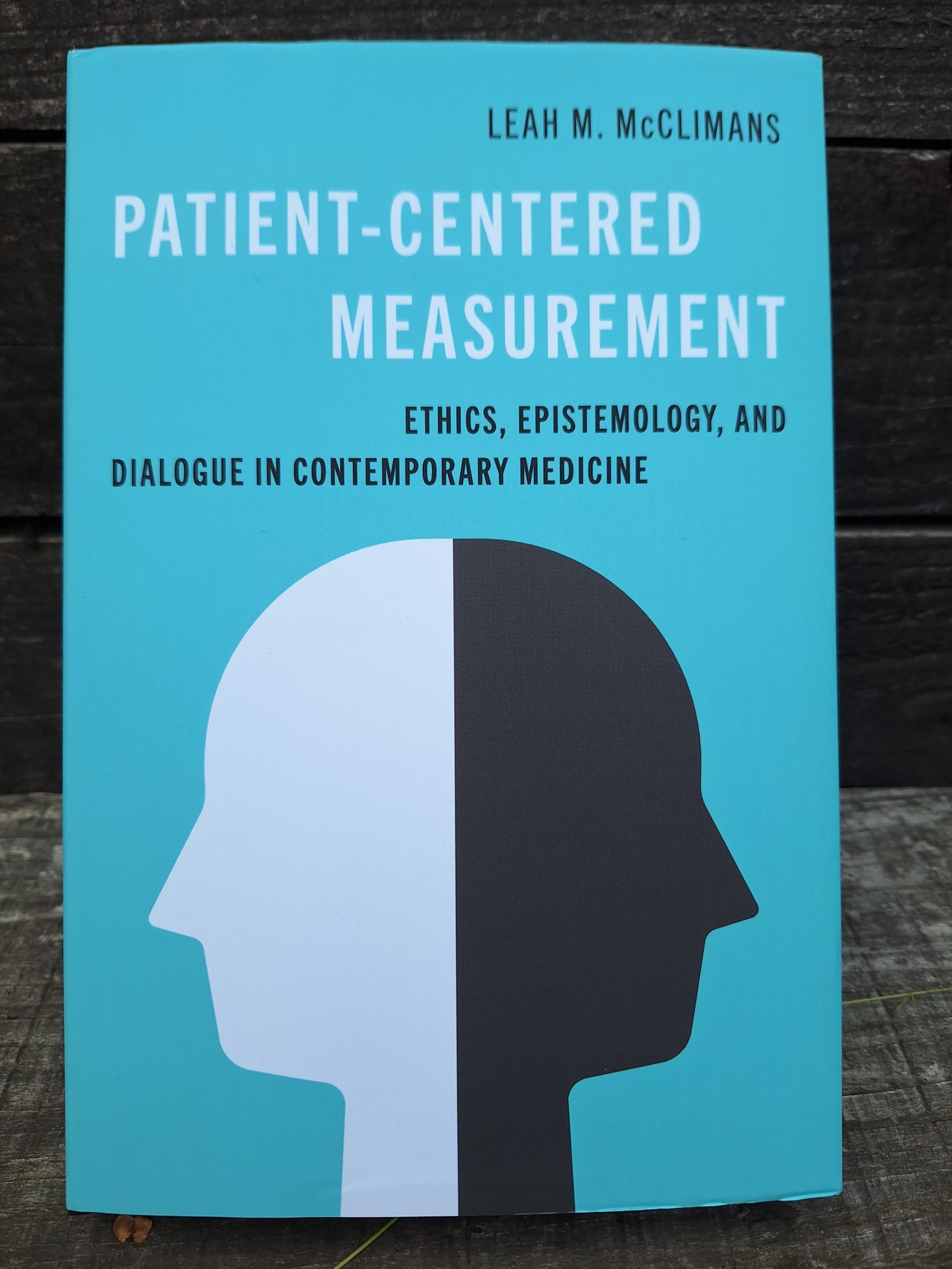 Picture of the cover of Leah M. McClimans' "Patient-centered measurement: Ethics, epistemology, and dialogue in contemporary medicine"
printed on light green background, and above stylised white and black head profiles, back to back, watching away from each other.