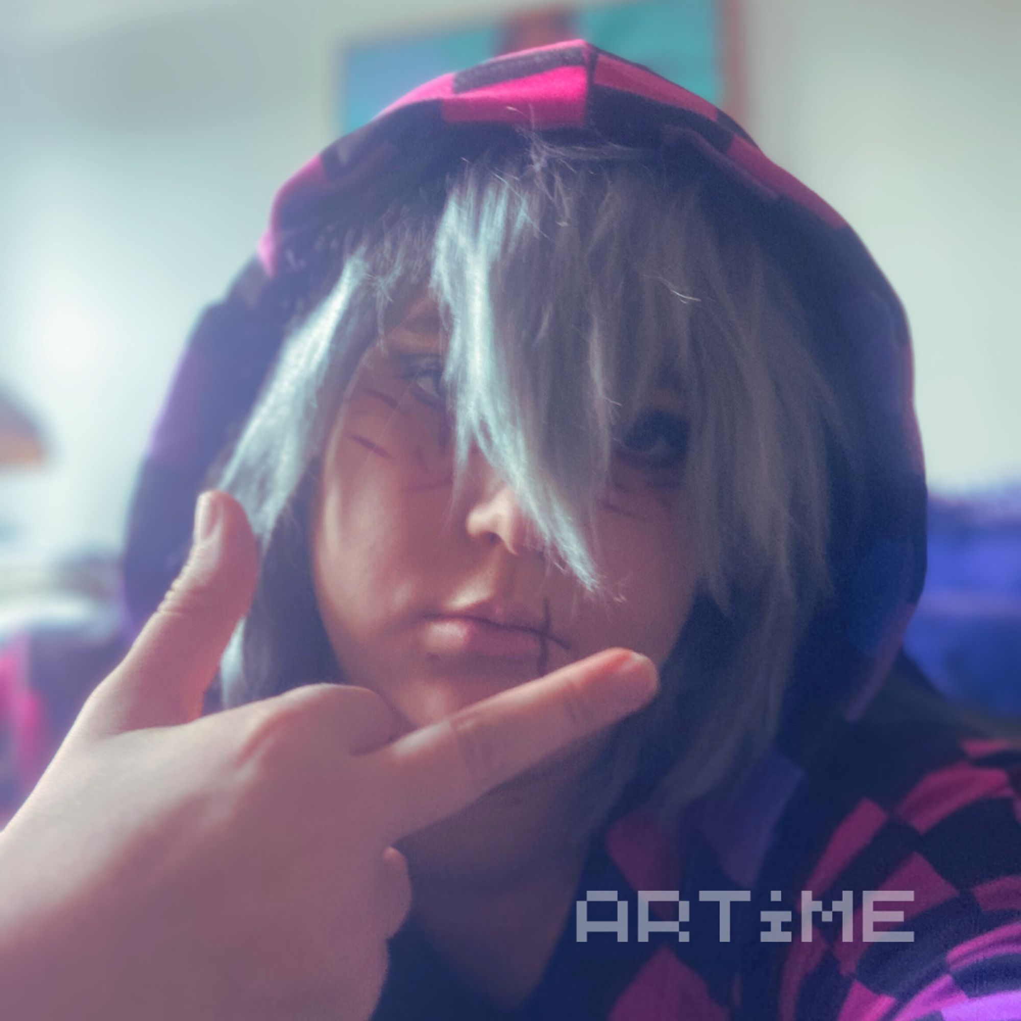 Tomura Shigaraki cosplayer flipping the bird and wearing a bisexual themed hoodie.