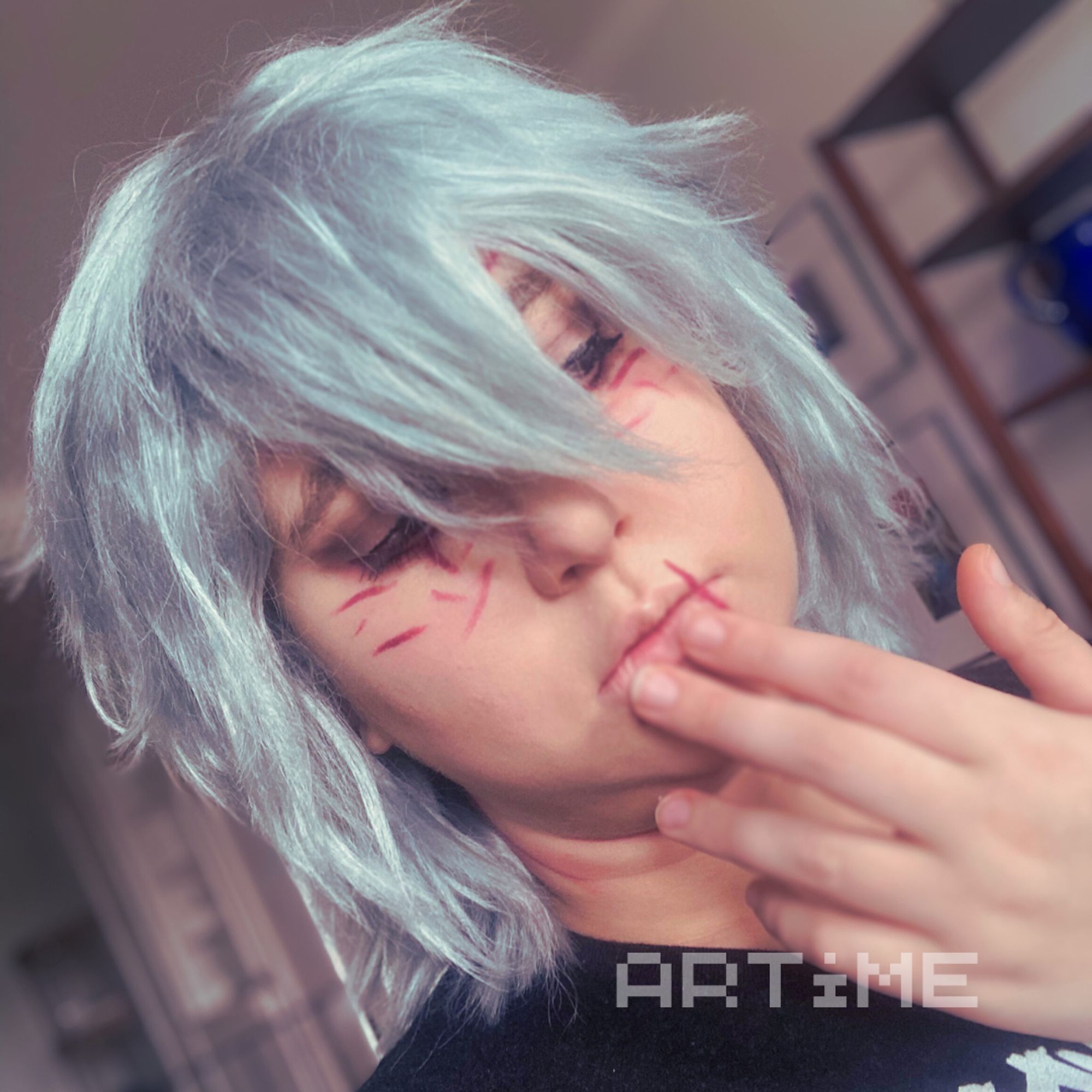 A Tomura Shigaraki cosplayer with his hand to his face and his eyes half closed.