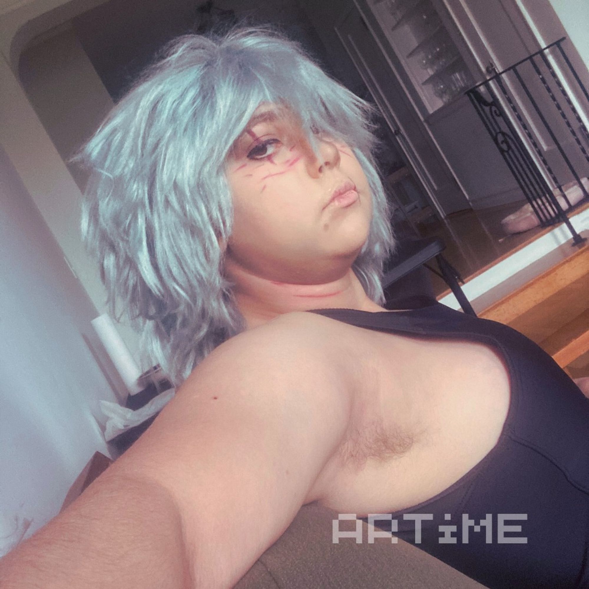 A Tomura Shigaraki cosplayer in a binder, and taking a selfie.