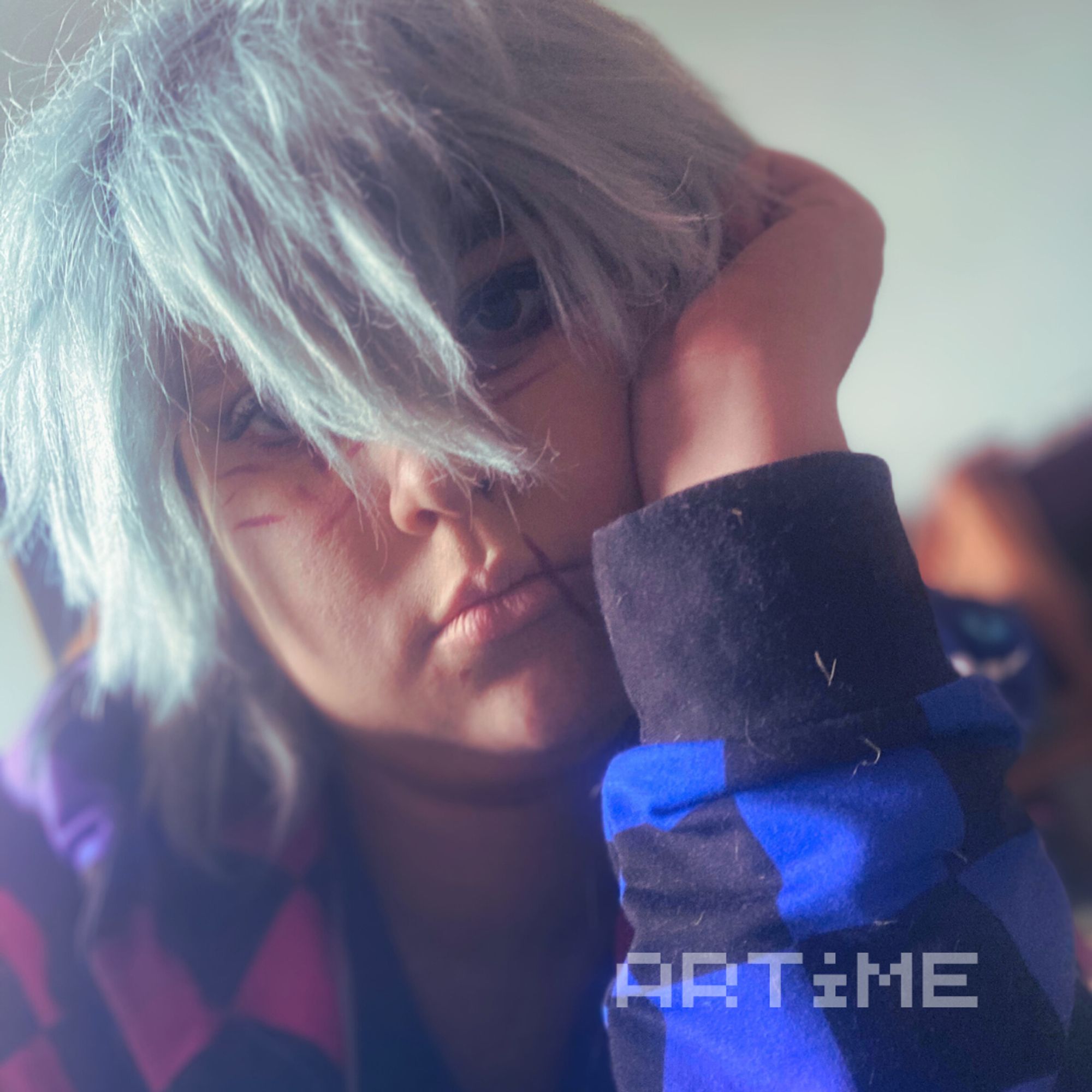 Tomura Shigaraki cosplayer leaning head into hand and wearing a bisexual themed hoodie.