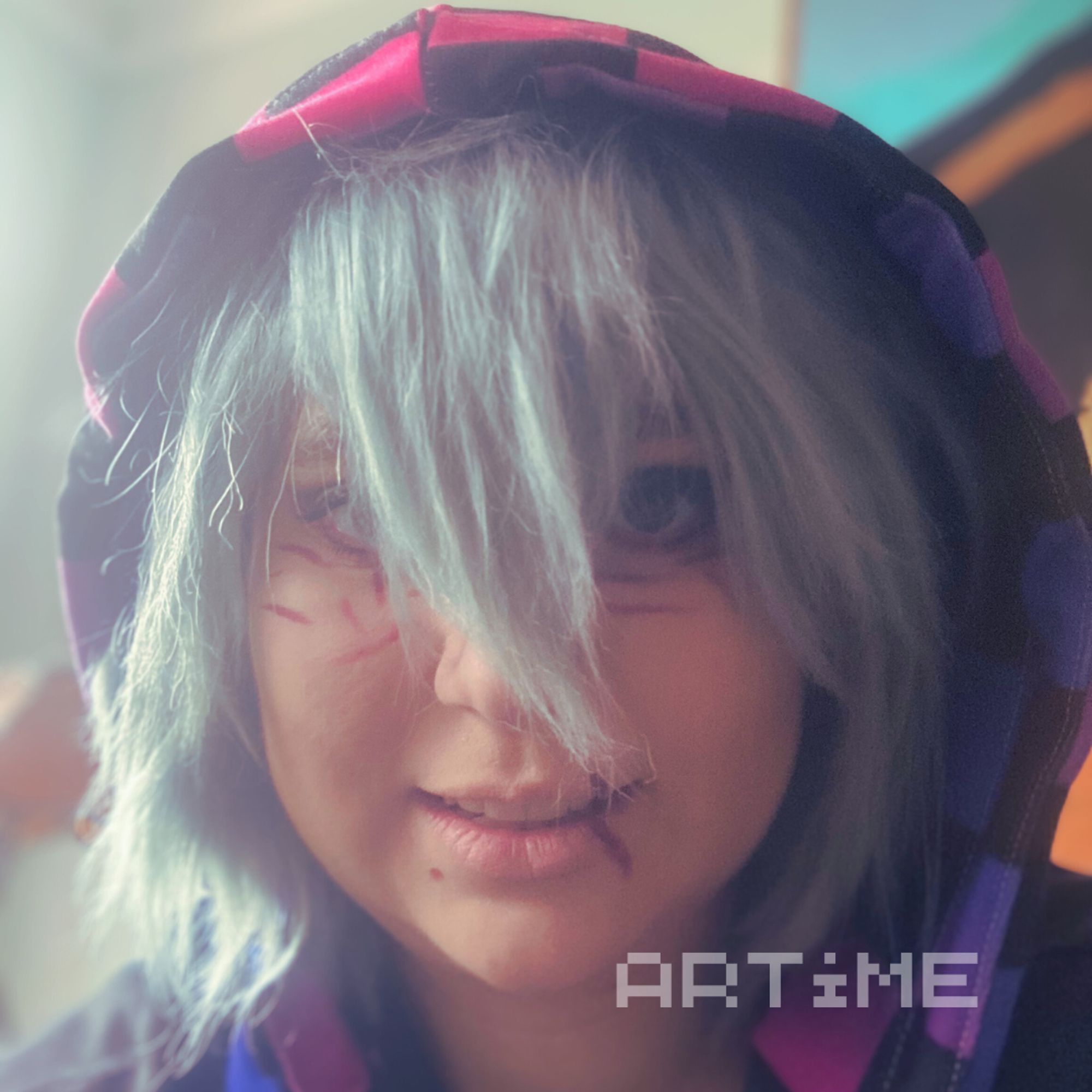 Tomura Shigaraki cosplayer looking into the camera and wearing a bisexual themed hoodie.