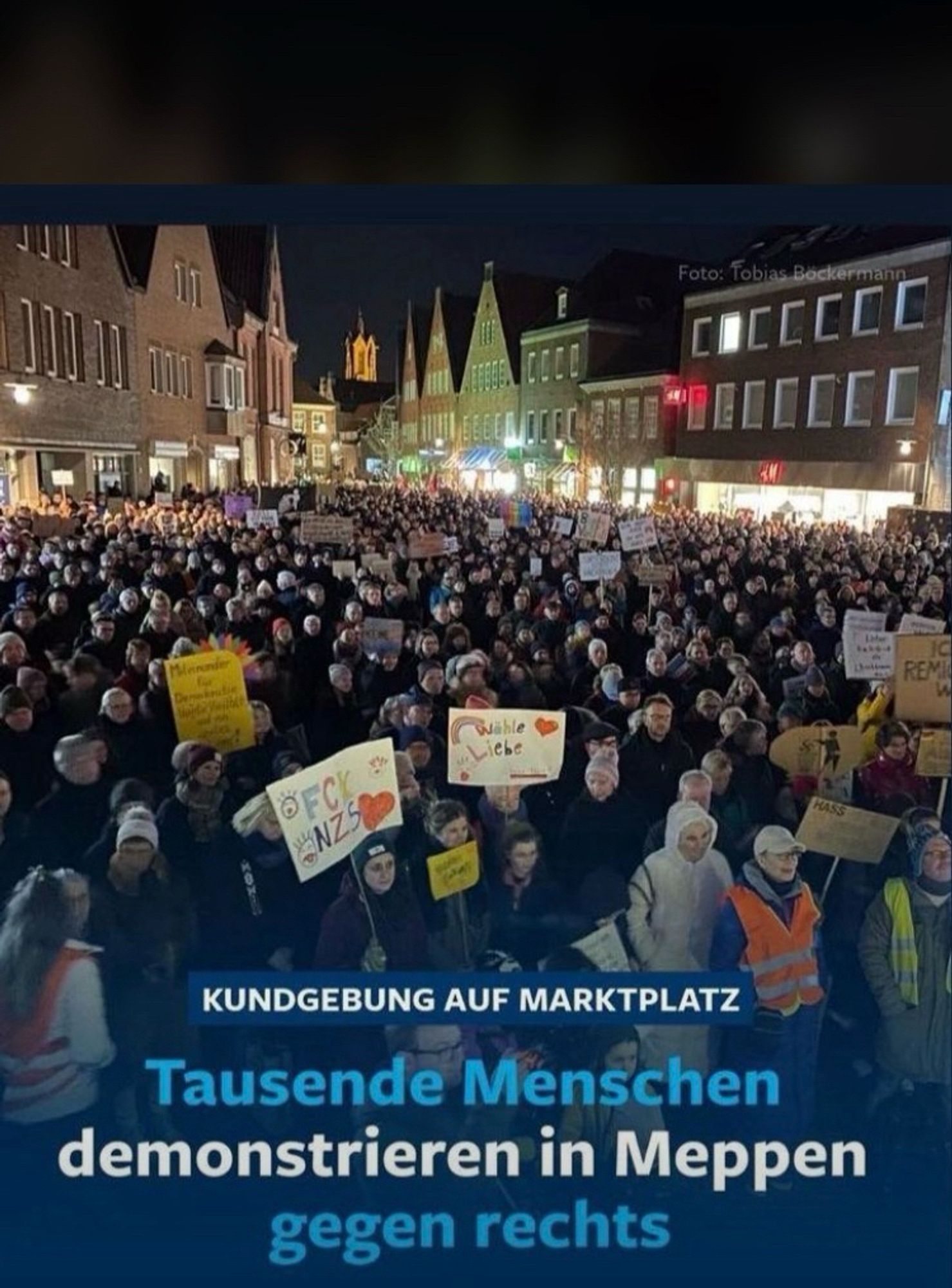 Foto mit dem Untertitel: Tausende Menschen demonstrieren in Meppen gegen rechts. Zu sehen sind sehr viele Menschen in der Fußgängerzone. Einige heben Schilder in die Höhe. Aufgenommen wurde das Foto von der Veranstaltungsbühne aus. Im Hintergrund sieht man noch den Turm der Propsteikirche.