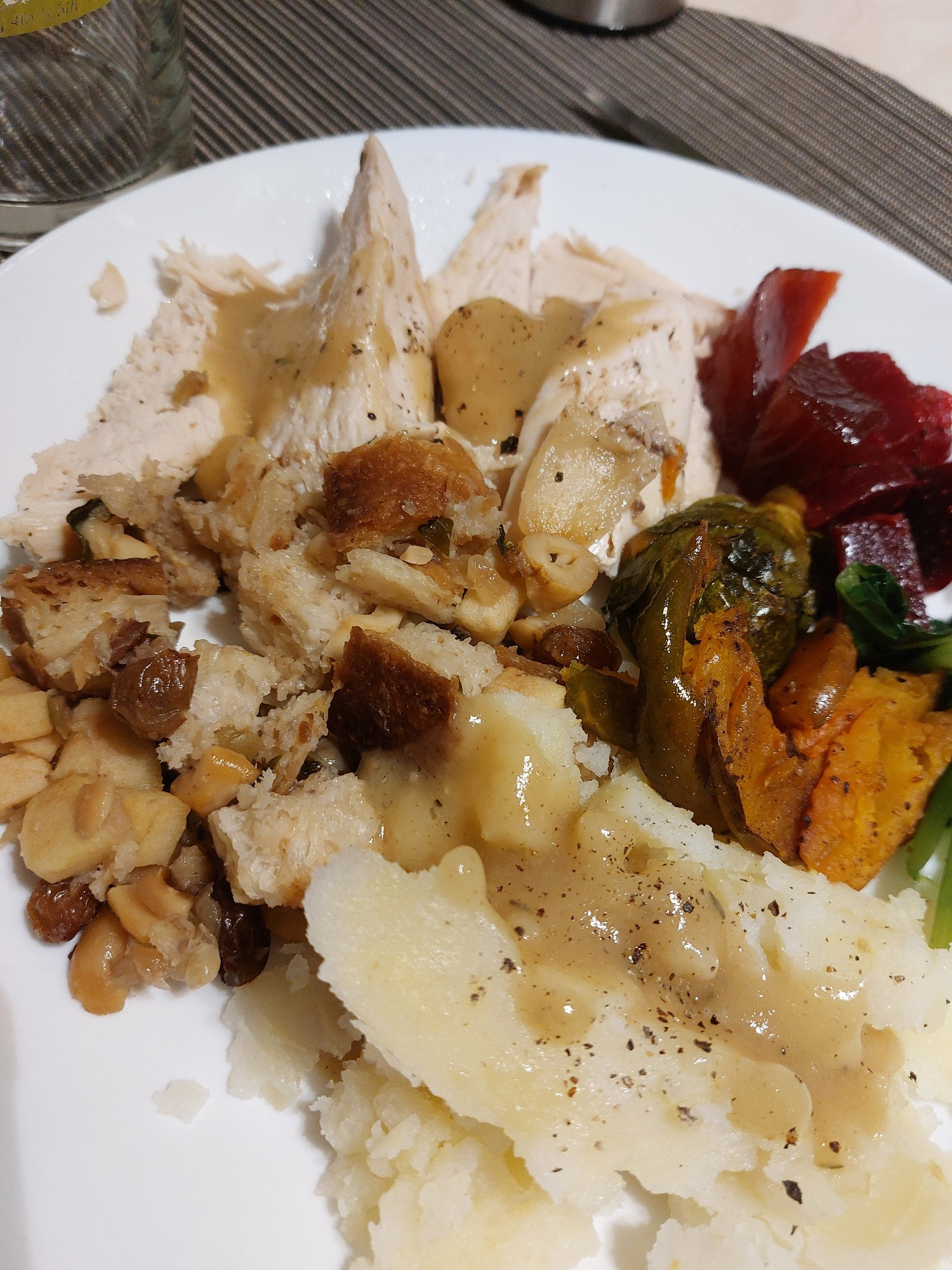 plate with turkey, sourdough stuffing, mashed potatoes, gravy, roasted squash and Brussels sprouts, beet salad, cranberry sauce