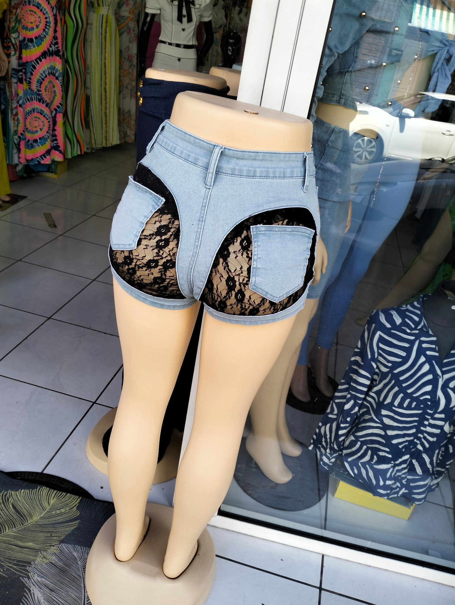 Short très court en jean. Le twist est que les poches arrière sont cousues sur une dentelle, rendant visibles presque toutes les jours des fesses. L'entrejambe reste en jean ceci dit.