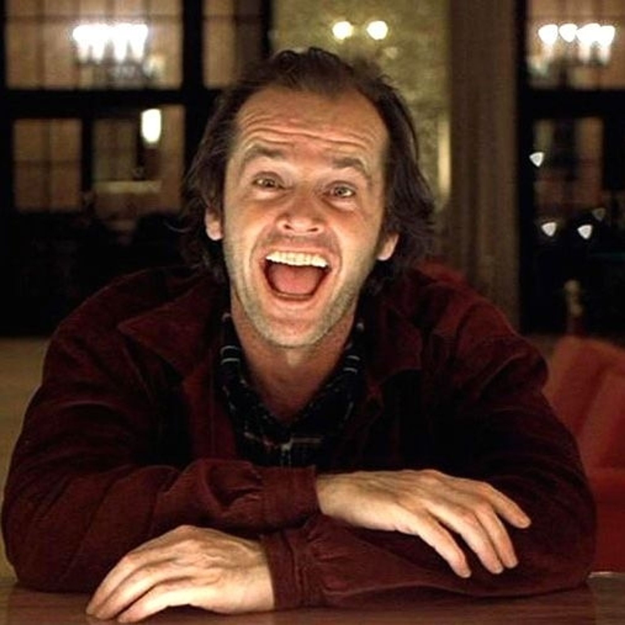 Jack Nicholson as Jack Torrance in Stanley Kubrick's The Shining. He is sitting at the hotel bar and laughing.