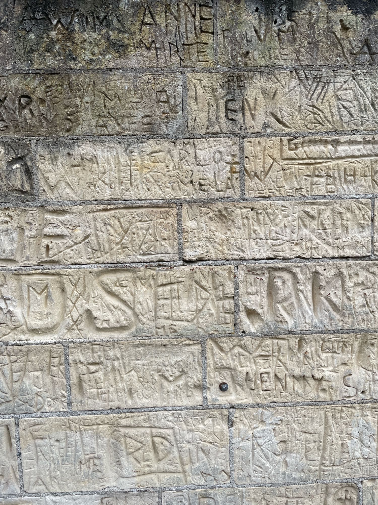 Marlstone wall with names carved in it.