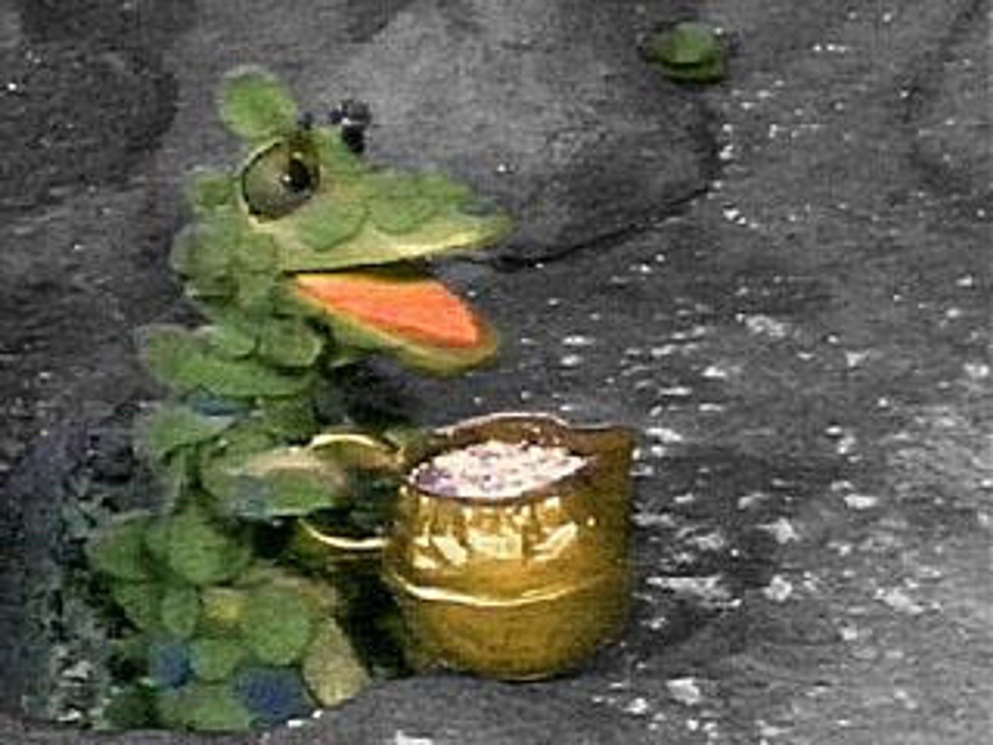 A picture of the green dragon from the Clangers universe, holding a kettle of soup.