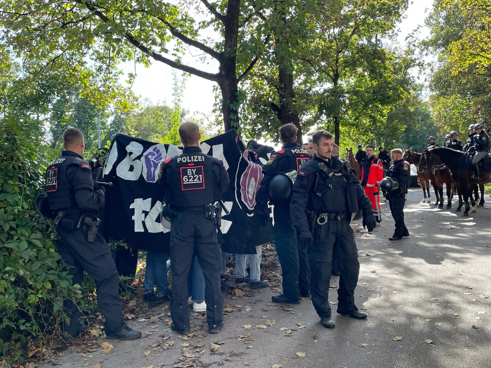 Polizeikräfte umstellen ein paar Gegendemonstrant*innen.