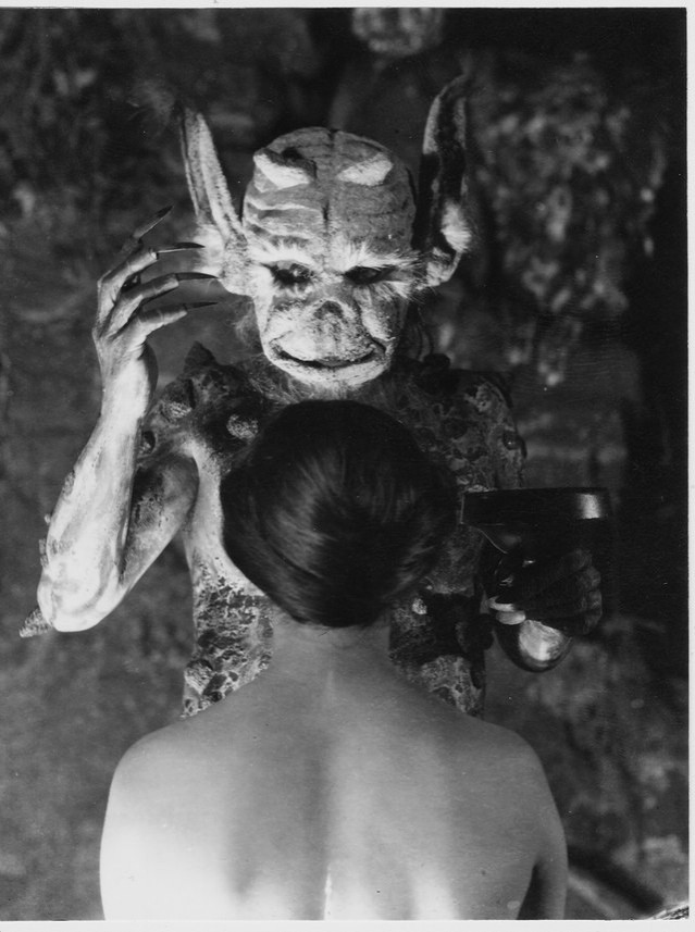 Image tiré du film Häxan, la sorcellerie à travers les âges (1922). Image en noir et blanc avec une femme de dos au chignon impeccable, faisant face à un démon dégueulasse