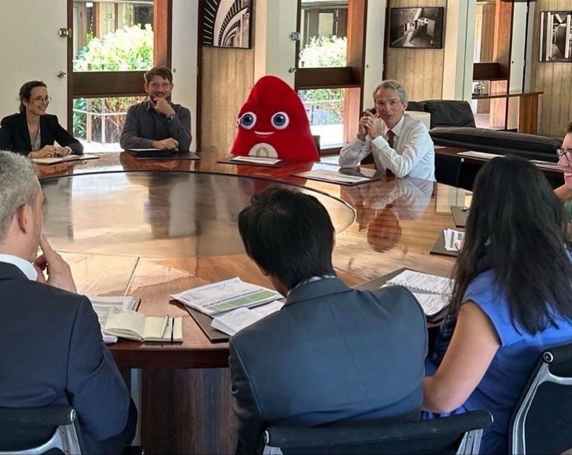 Image du meme de la mascotte de la frige olympique, autour d'une table de réunion