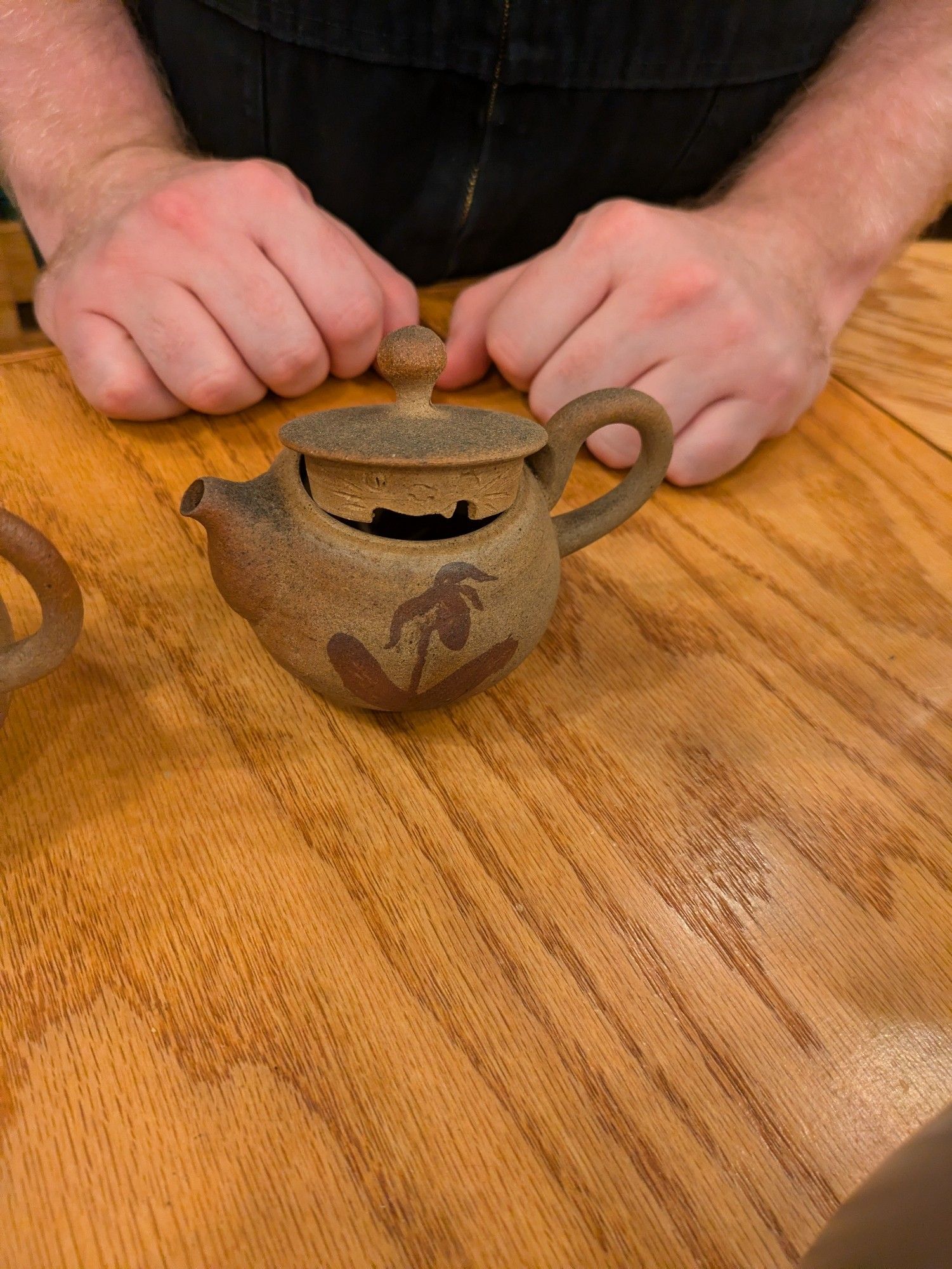 A tiny teapot (smaller than a fist) with a smiling cat carved into the side of the lid, where it will be invisible when closed and thus be a super cute hidden joy for those opening the pot.