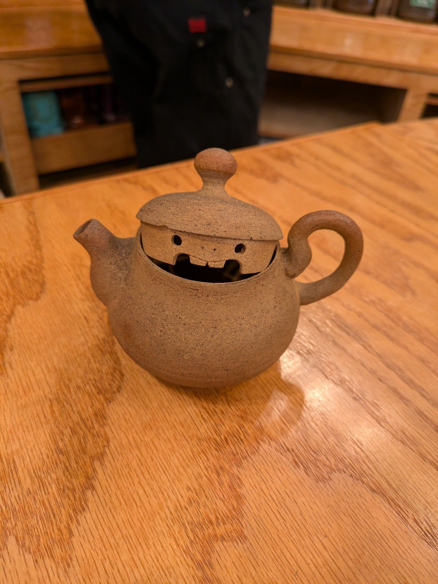 A tiny teapot with a smiling beaver face with buck teeth carved into the side of the lid, where it will be invisible when closed and thus be a super cute hidden joy for those opening the pot.