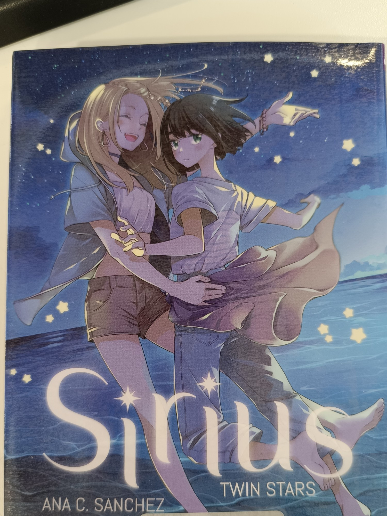 Manga. Titre : Sirius twin stars. Couverture représentant deux filles qui s'enlacent sur la plage de nuit.