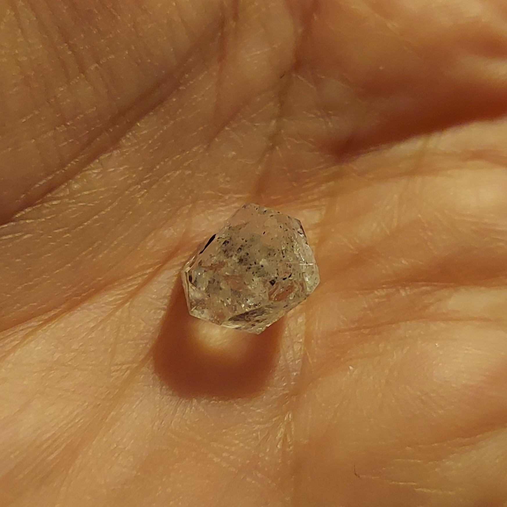 Small raw diamond with tiny black inclusions