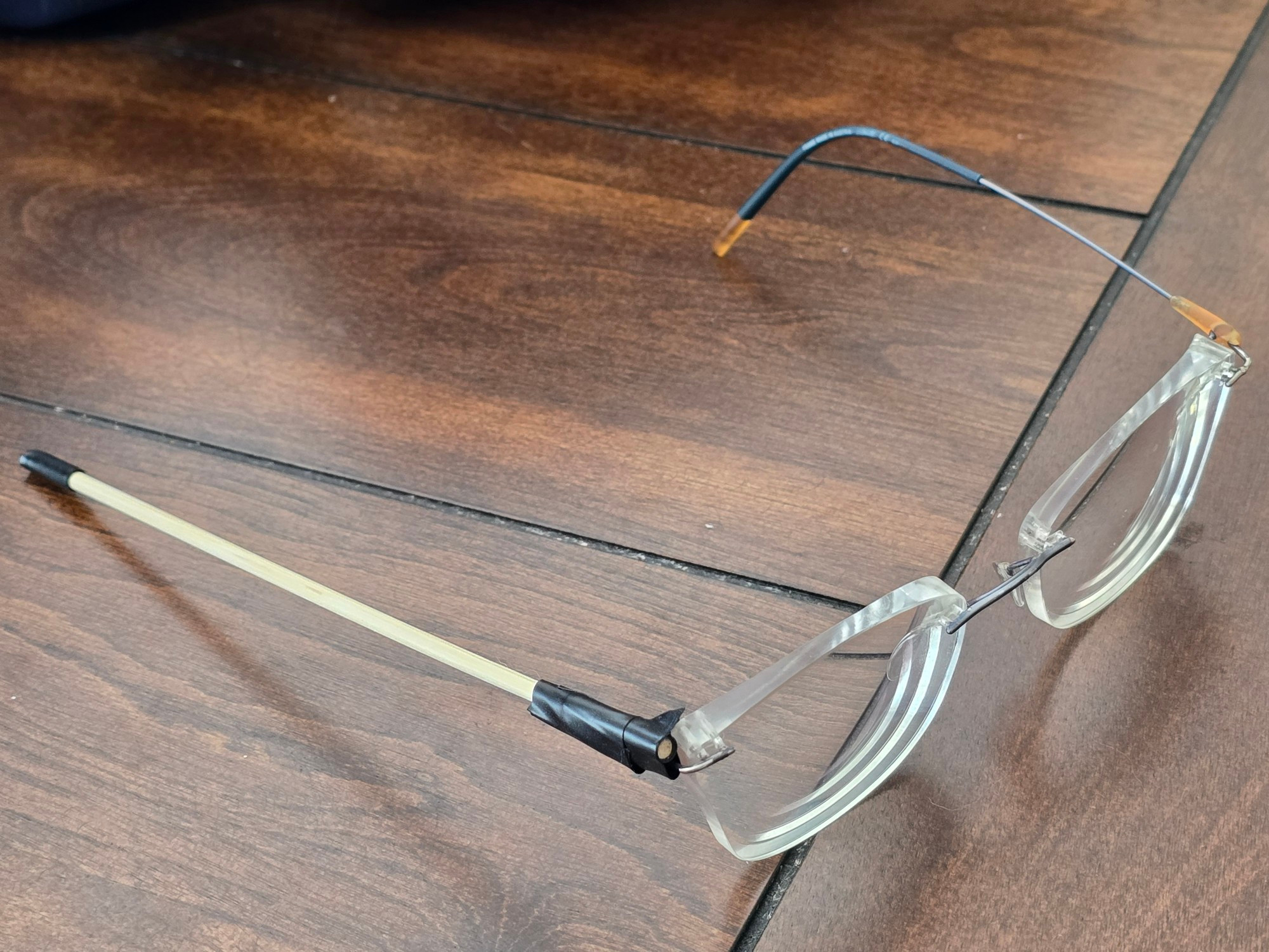 Glasses that are "fixed" by replacing one missing arm with a wooden towel poorly taped to the hinge.