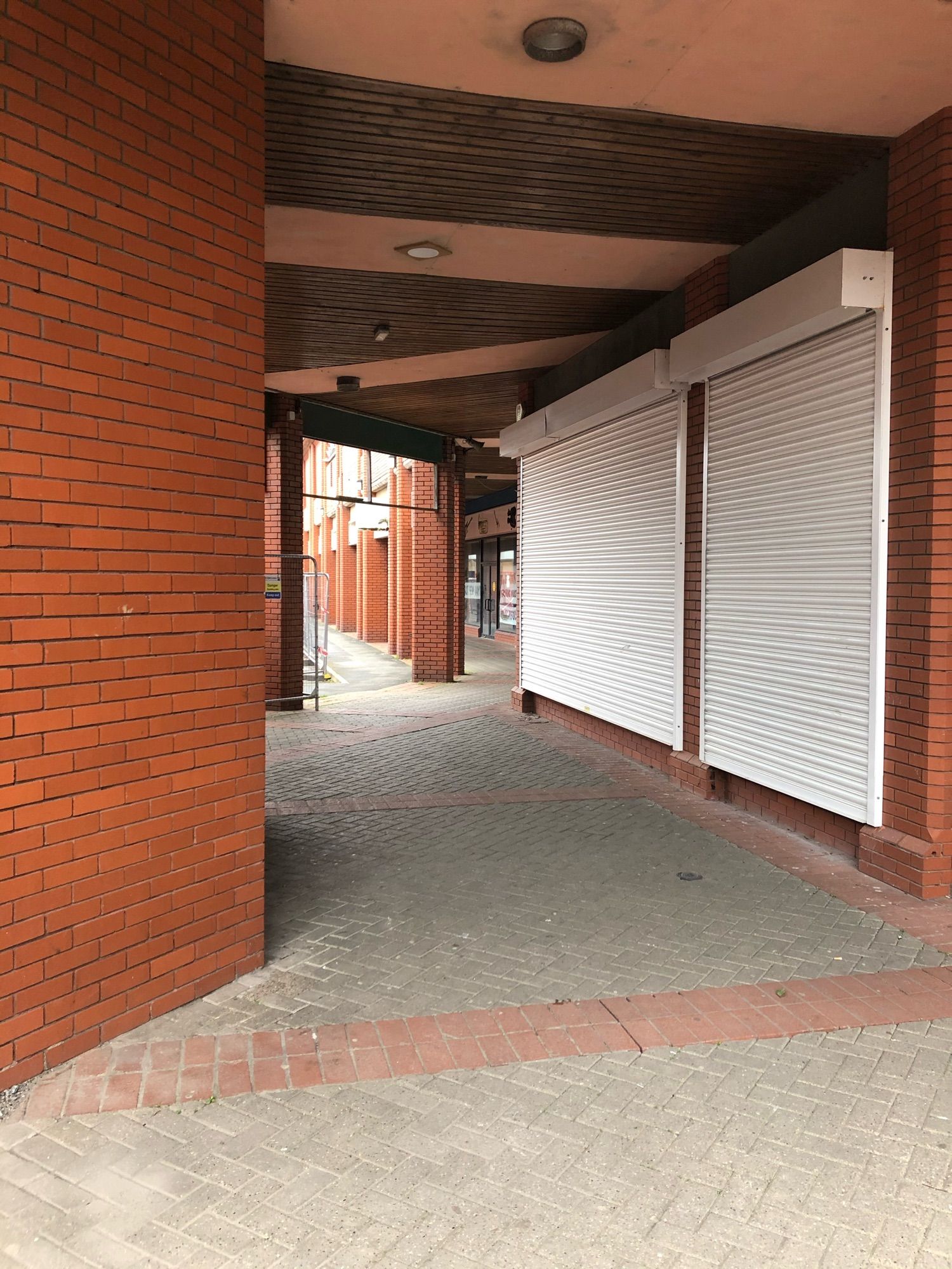 A covered walkway in the red-brick open-air St. David’s Shopping Centre in Swansea.