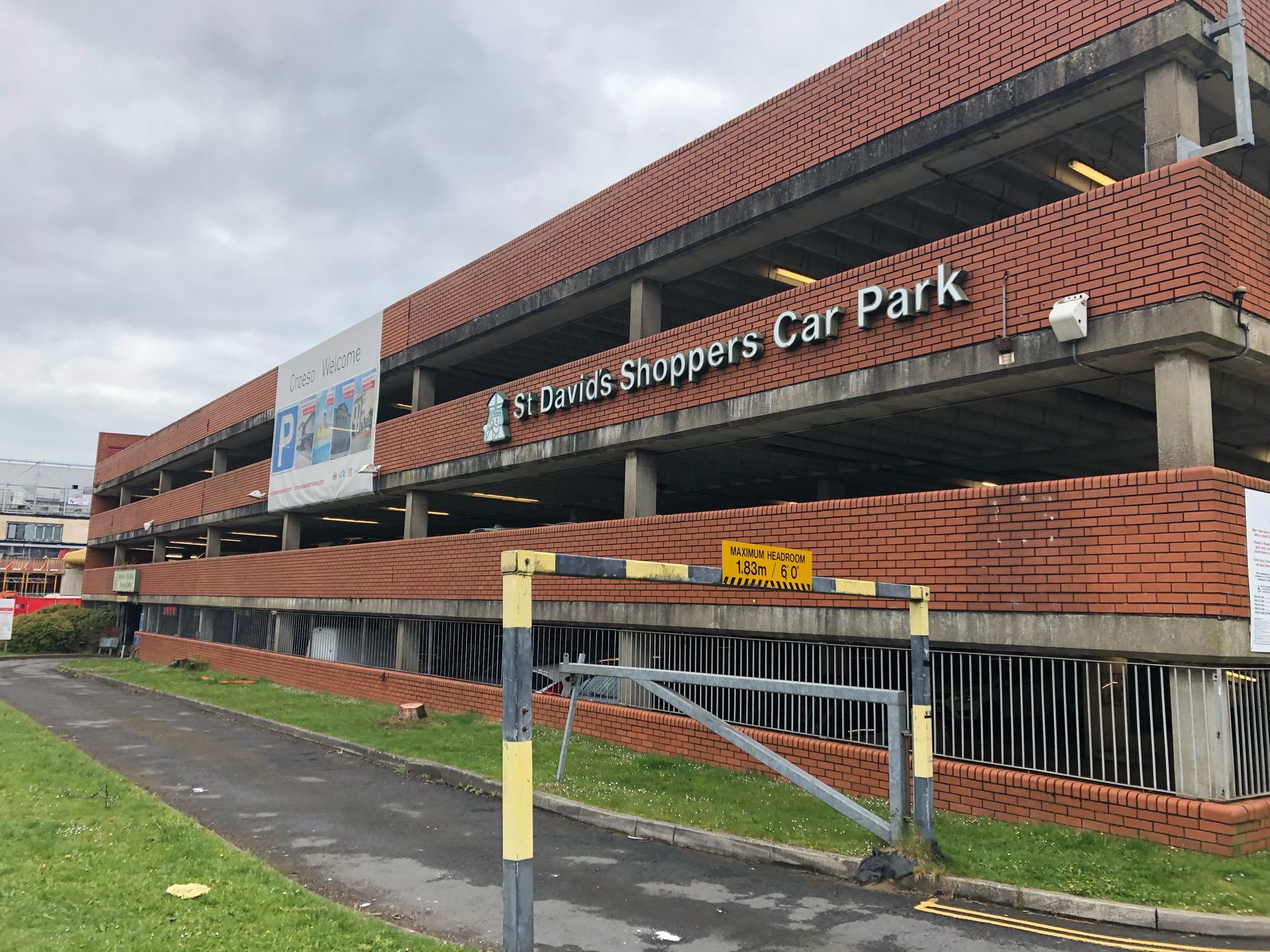 The tired red-brick multi-storey car park at the edge of St. David’s Shopping Centre in Swansea. The sign says ‘St. David’s Shoppers Car Park’.