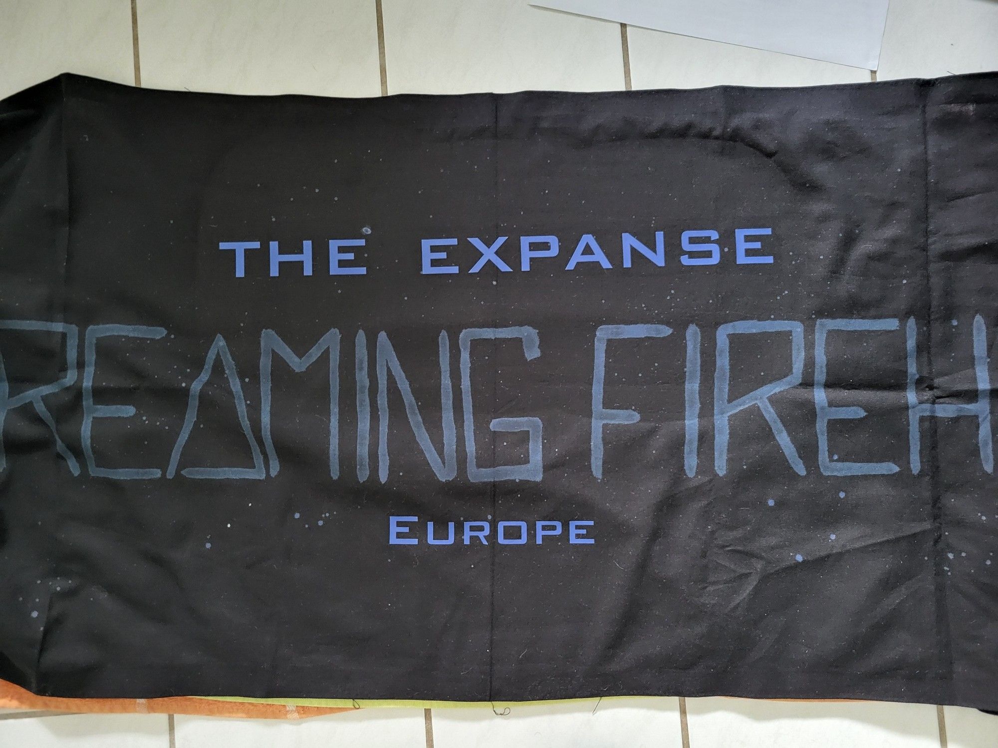 A black banner with the words #ScreamingFirehawks in a shaddy blue and "The Expanse Europe" in a more vibrant blue.