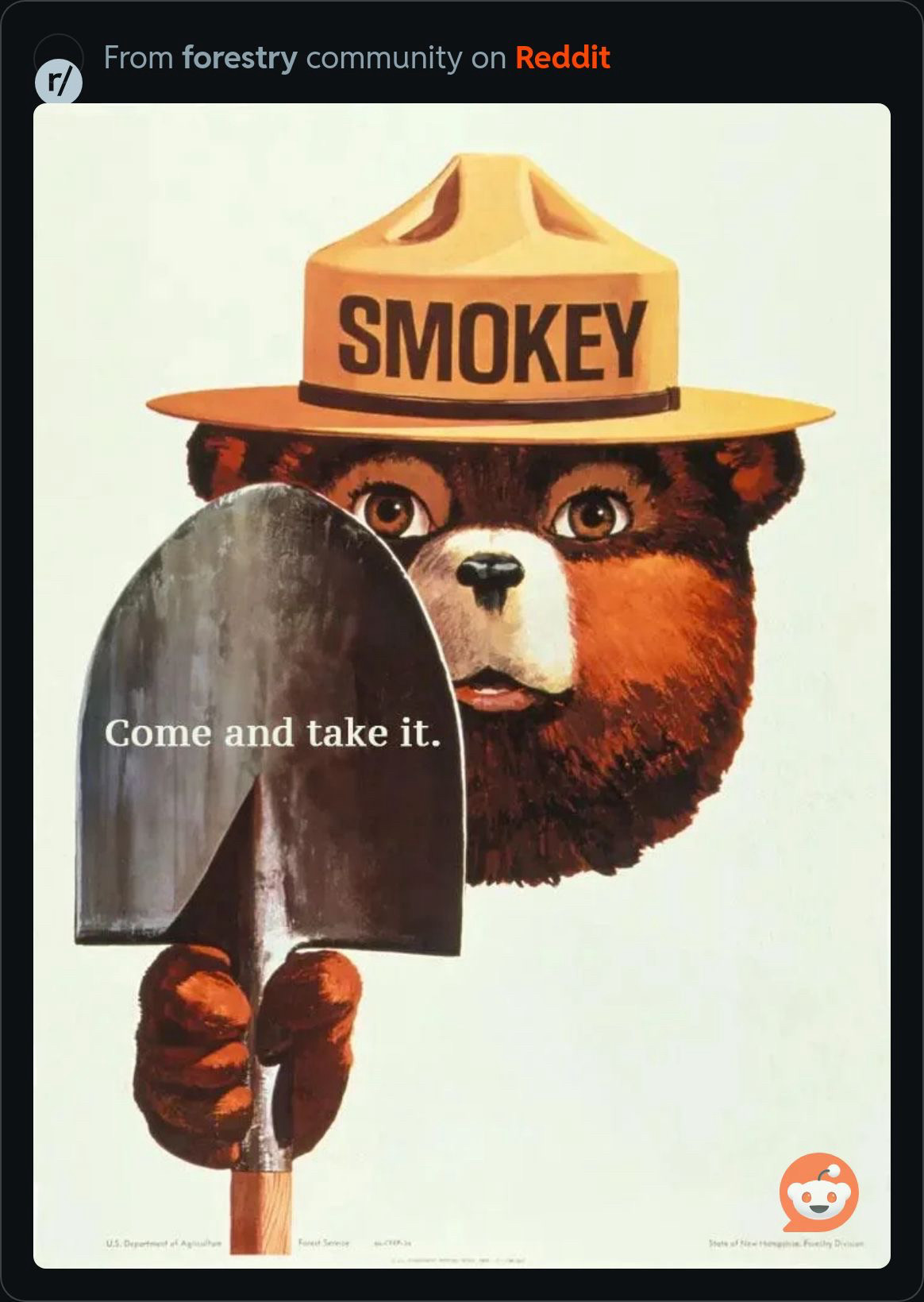 Smokey Bear with a shovel for firefighting that says “come and take it.”