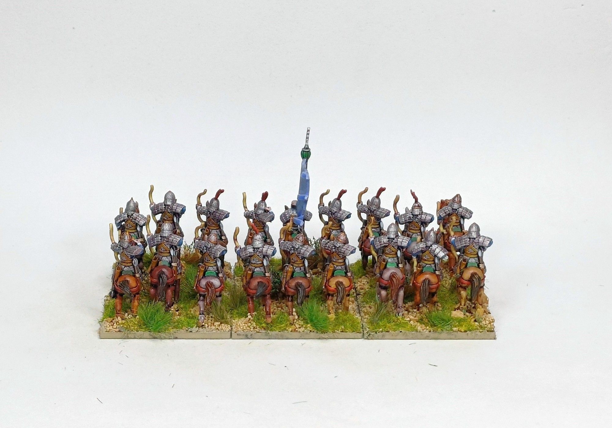 18 15mm armoured horse archers in 2 ranks of figures. Horses are unarmoured, all the men are holding a bow; some shooting, some reaching for a new arrow. They face away from the camera.