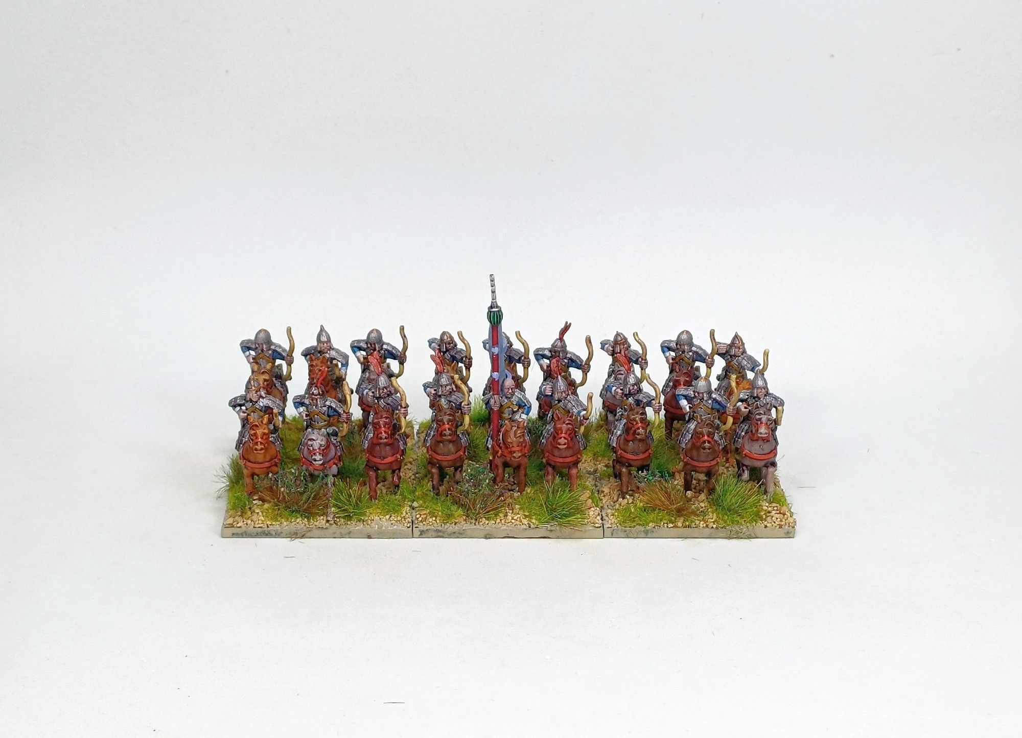 18 15mm armoured horse archers in 2 ranks of figures. Horses are unarmoured, all the men are holding a bow; some shooting, some reaching for a new arrow. They face the camera.