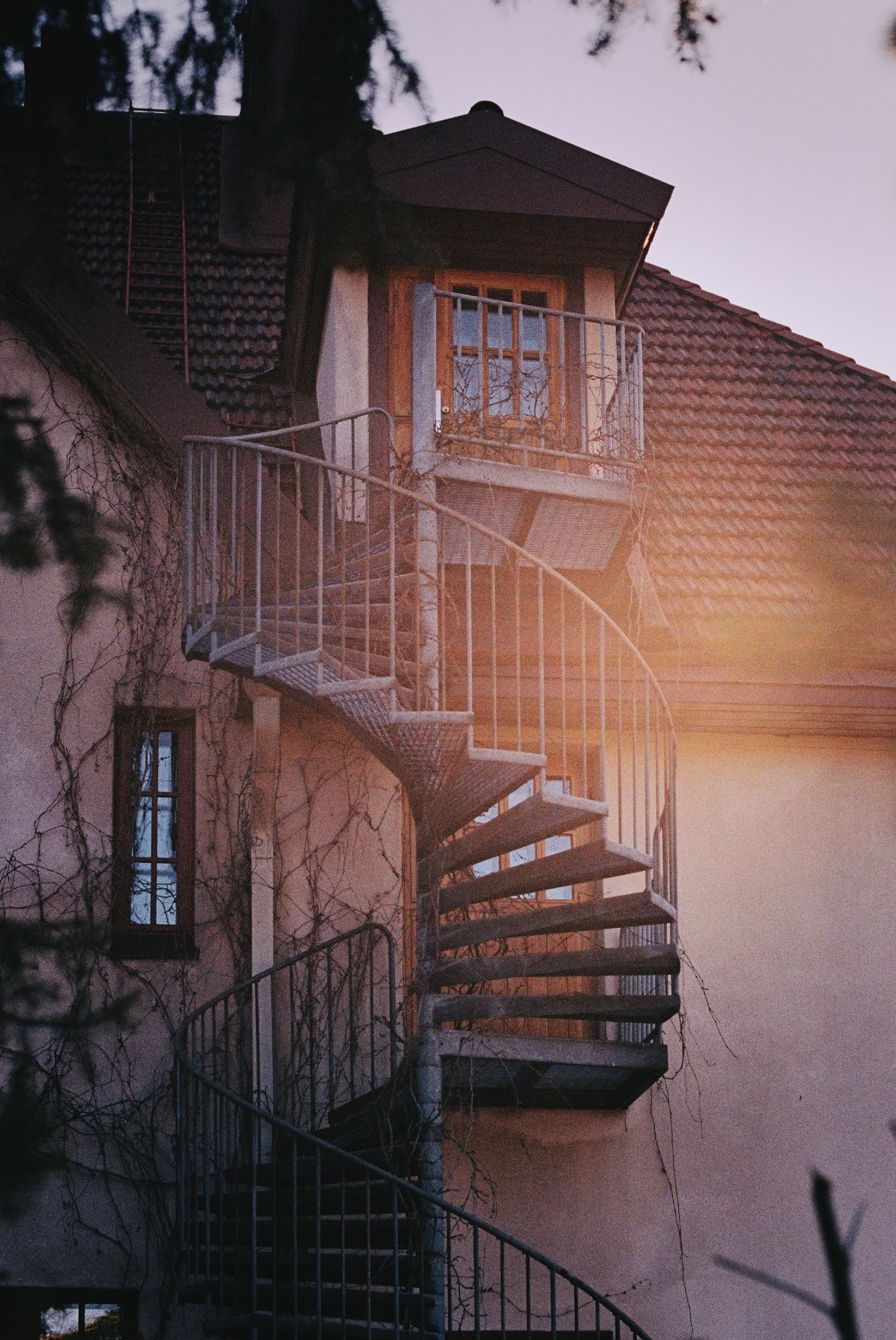 Spiral staircase leading up to a windowed door.