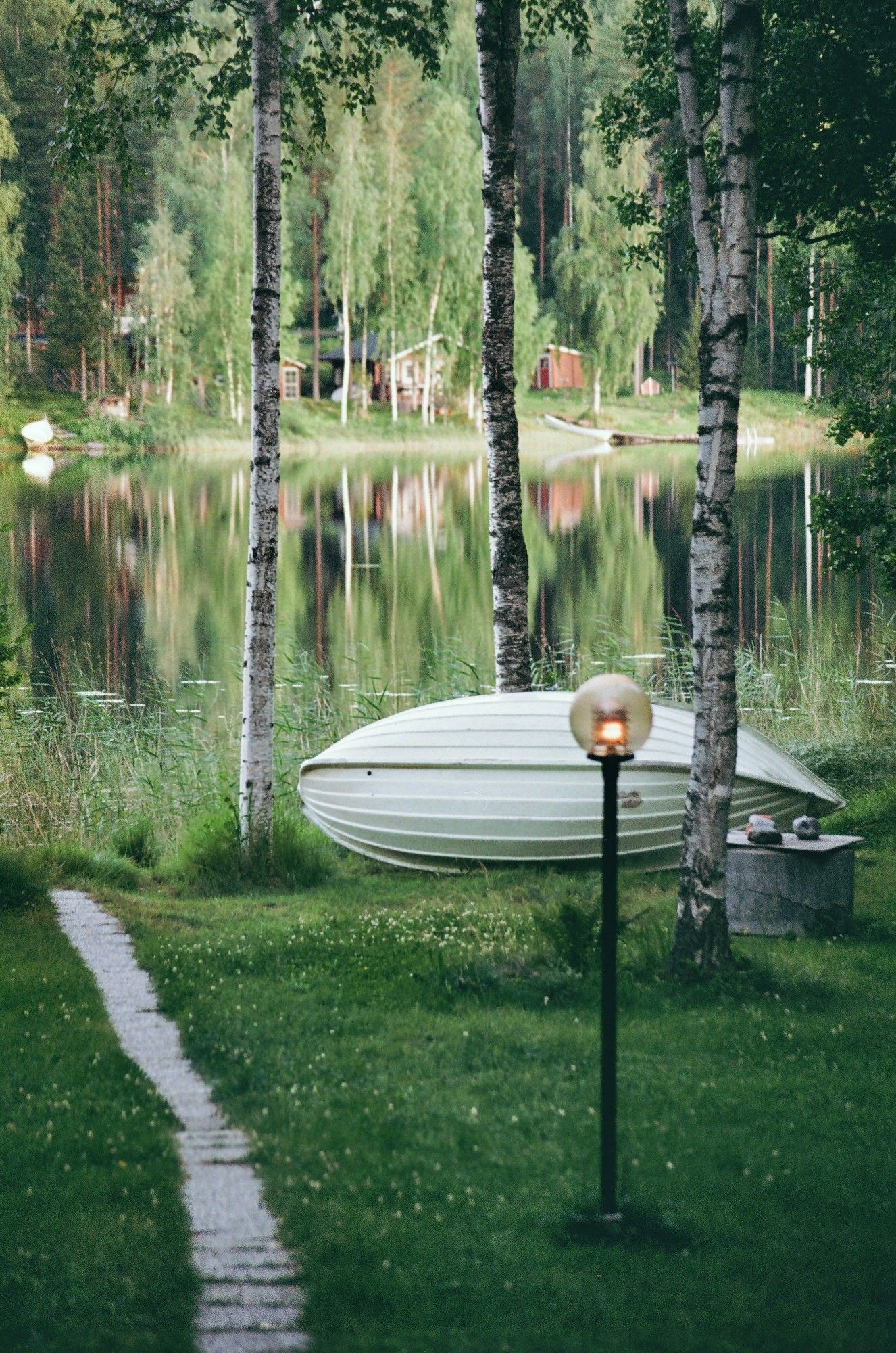 A boat and a lamp post at the side of a lake