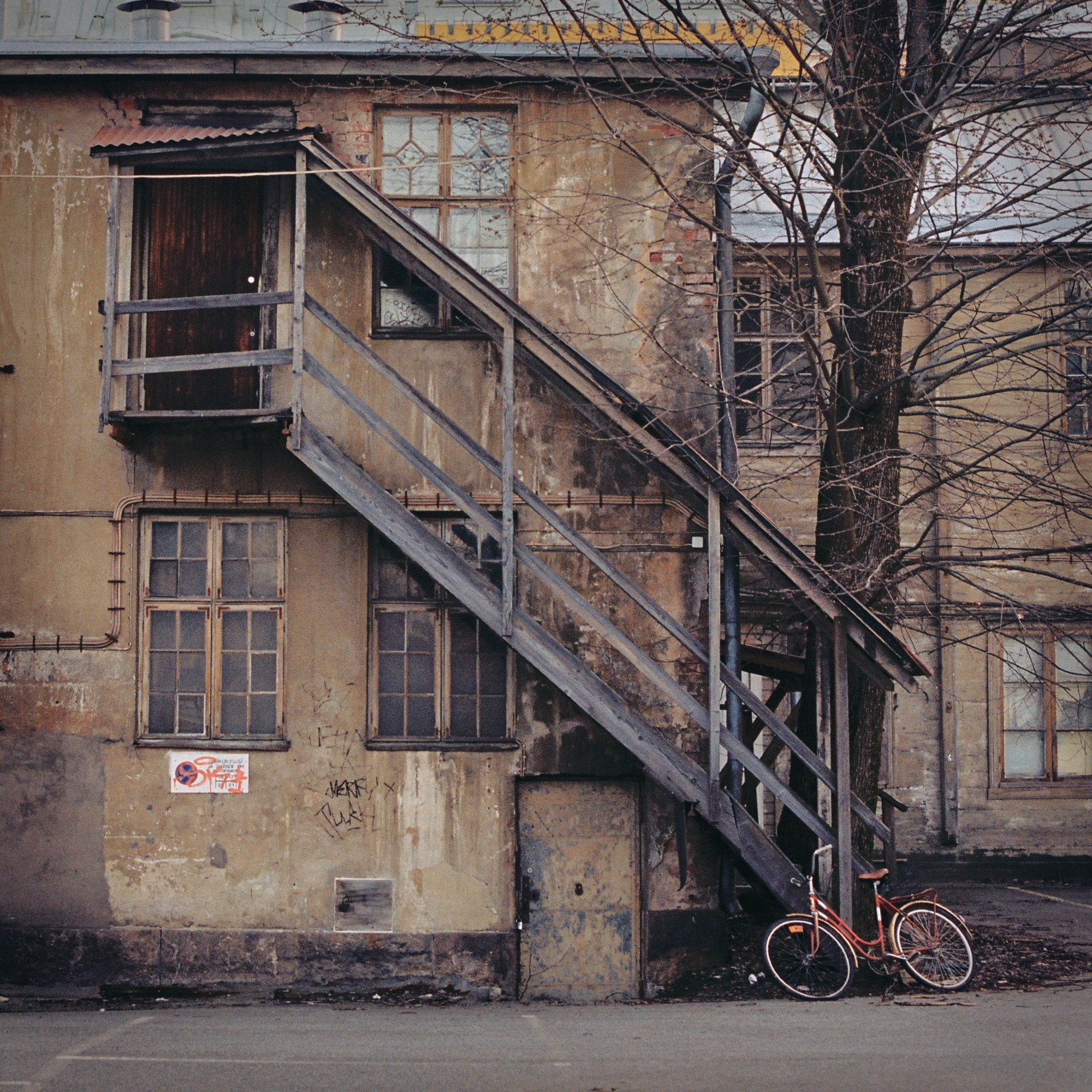 Worn down stairs leading down to a bicycle outside.