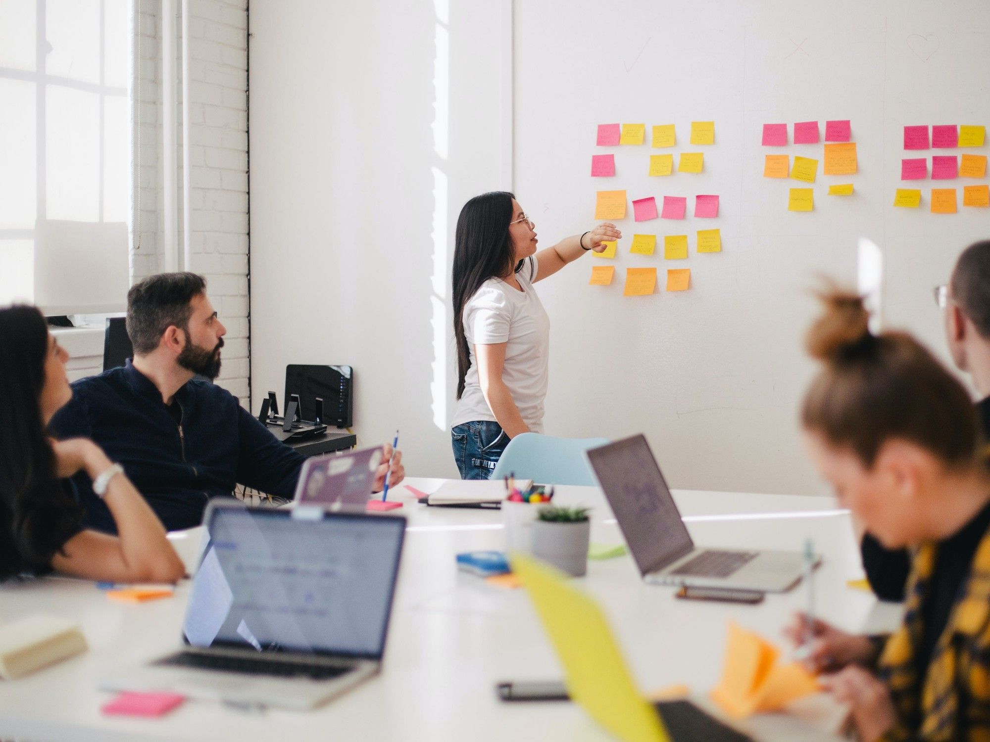 Seminargruppe arbeitet mit Haftnotizen an der Wand