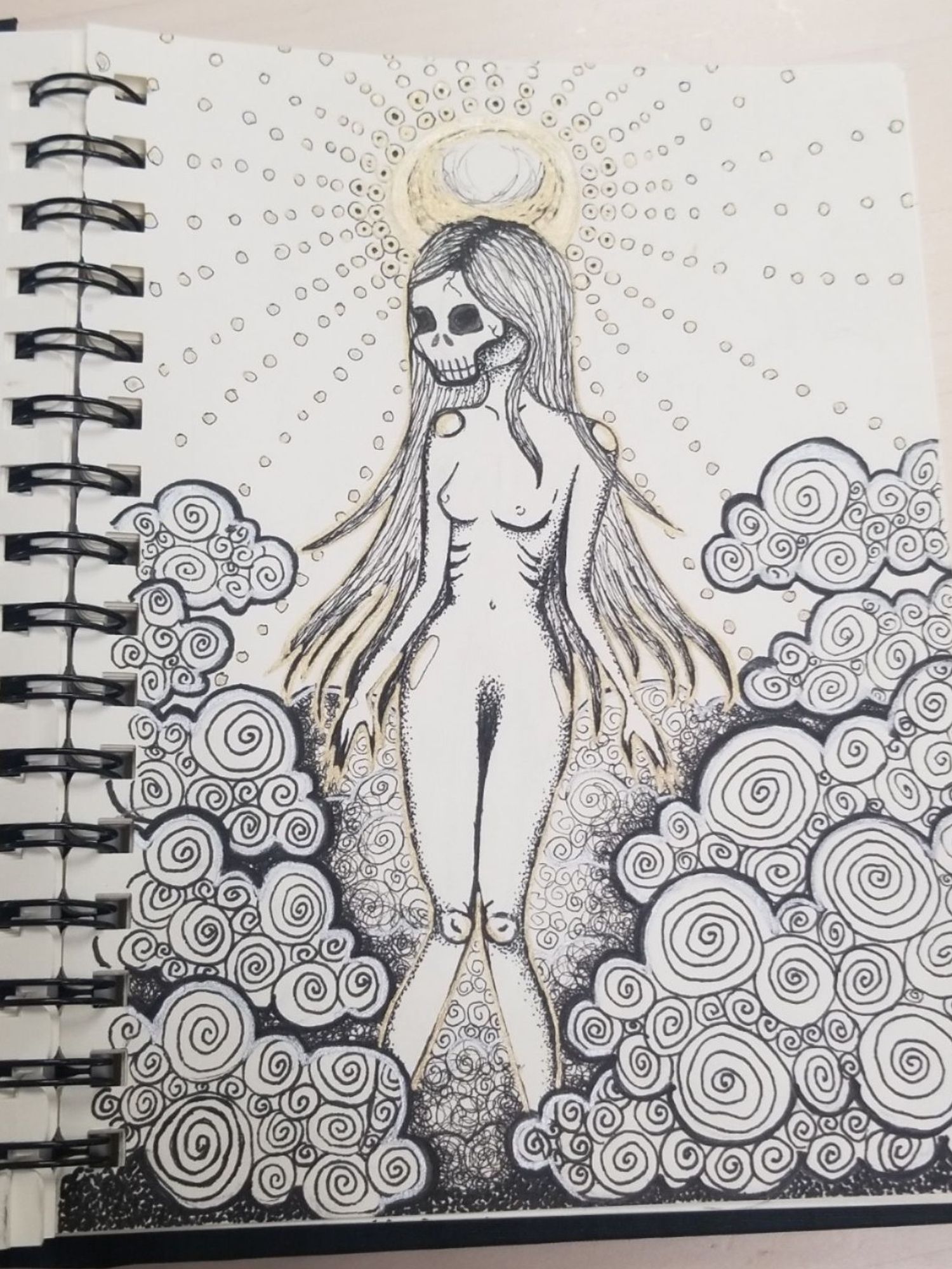 Drawing of a skinny fem creature with a skull for a face. She's naked and has long stringy black hair. She's surrounded by fog. A sun is right behind the creature. Making it look like a halo.