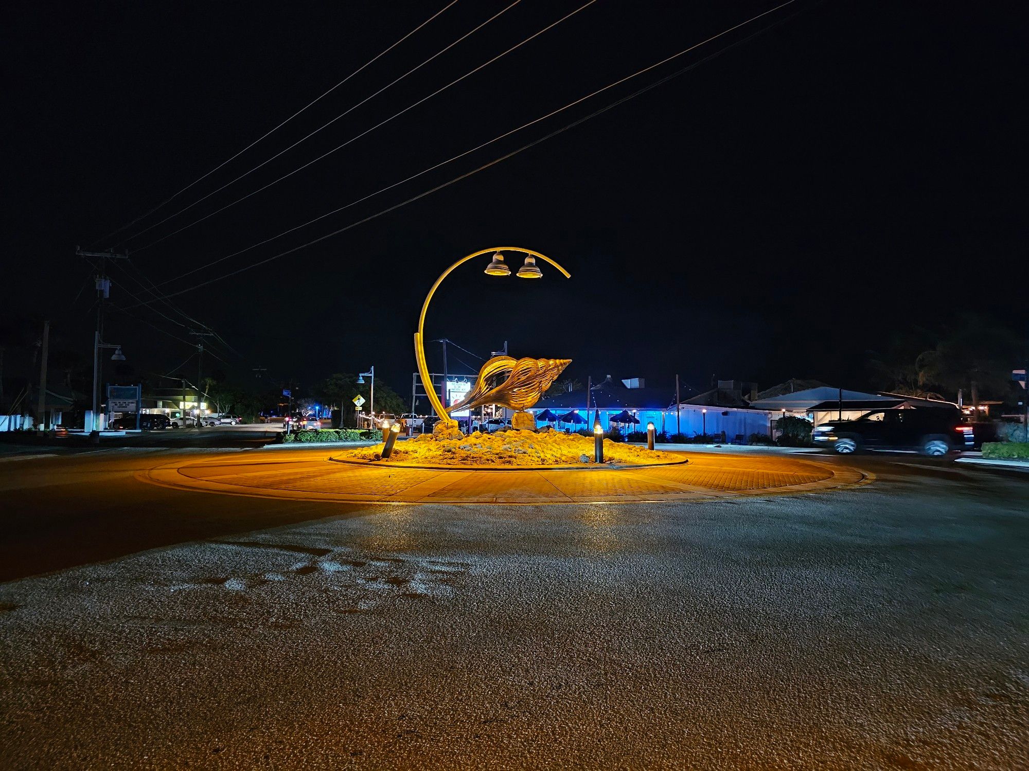 Metal seashell sculpture in the middle of a traffic roundabout.